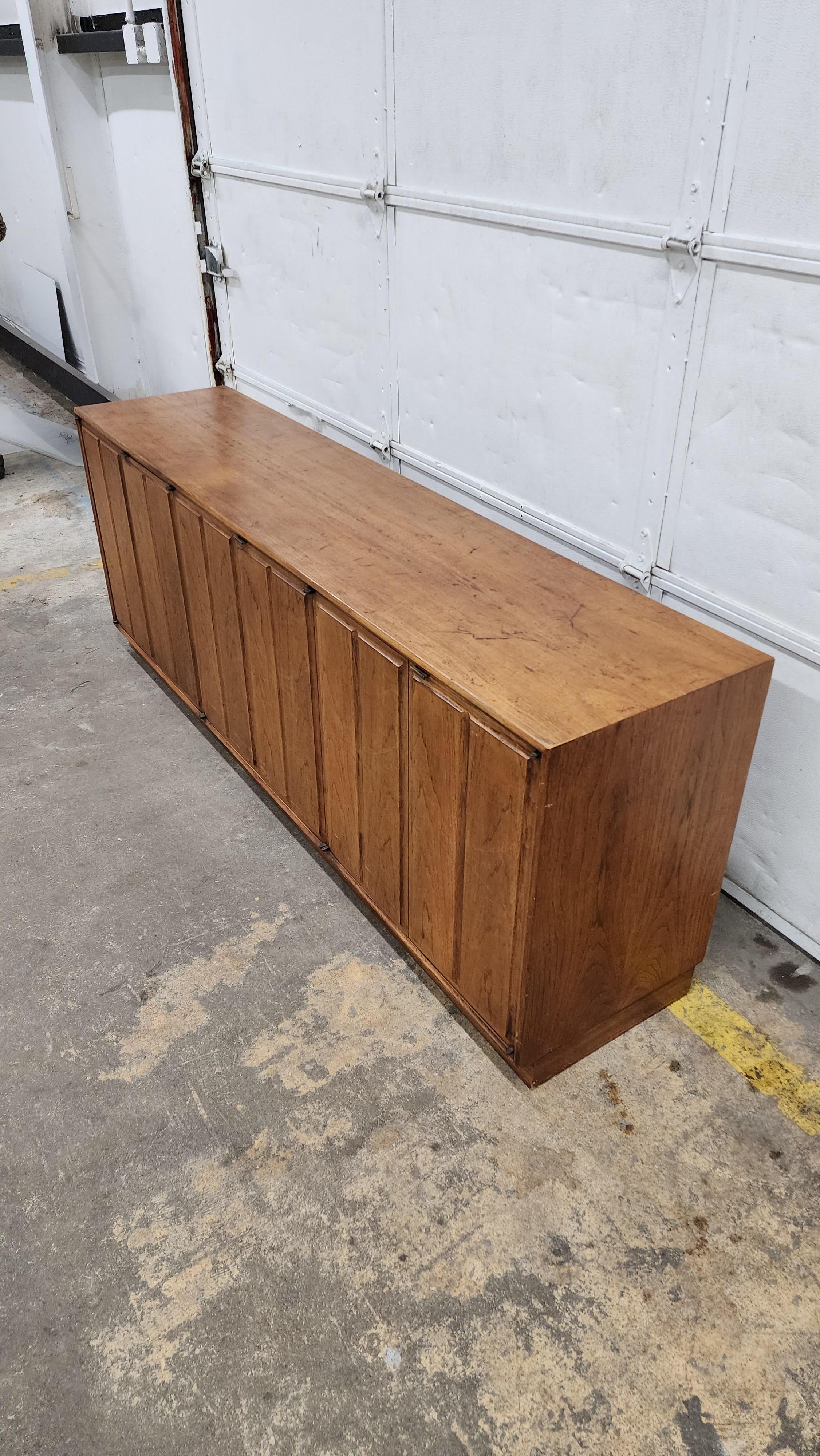 walnut credenza with speckled finish.  doors open to reveal 1 drawer in each section.  shelf can be added. holes in back for a/v equipment. 