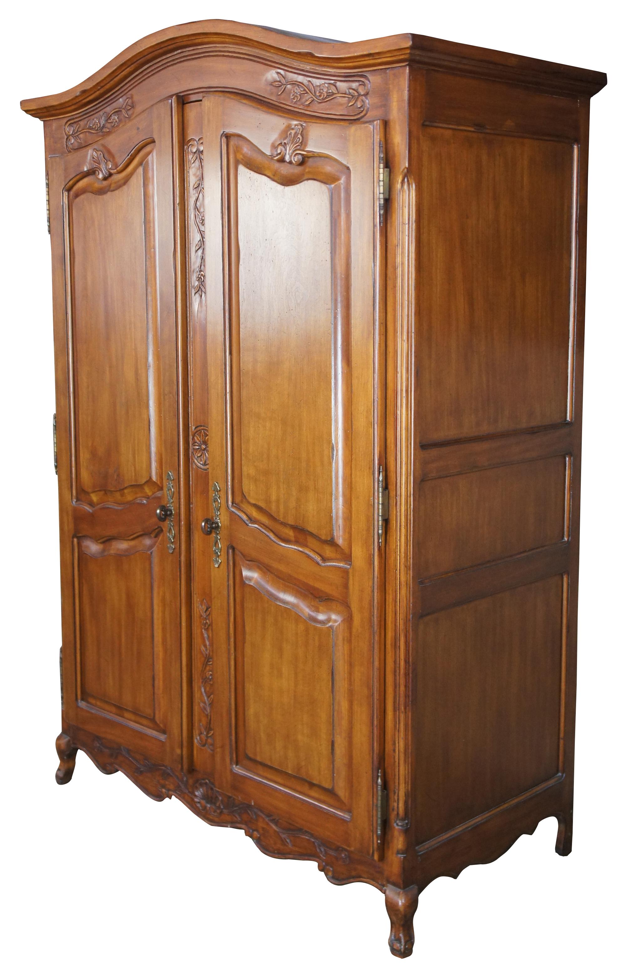 Vintage French Country armoire or wardrobe. Made of walnut with French styling with carved florals, shells, leaves with a central floral medallion and serpentine accents. Made in Mexico. Measure: 77