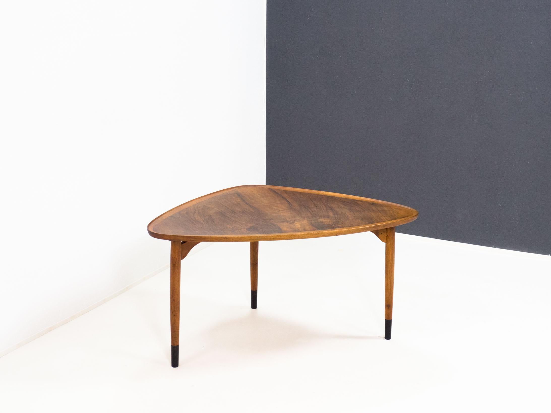 Danish design triangular coffee table from Denmark, 1950s.

This table is veneered in mirrored walnut on the top and has solid walnut edges and legs.

We have unfortunately been unable to find a maker or designer for this table, despite of its