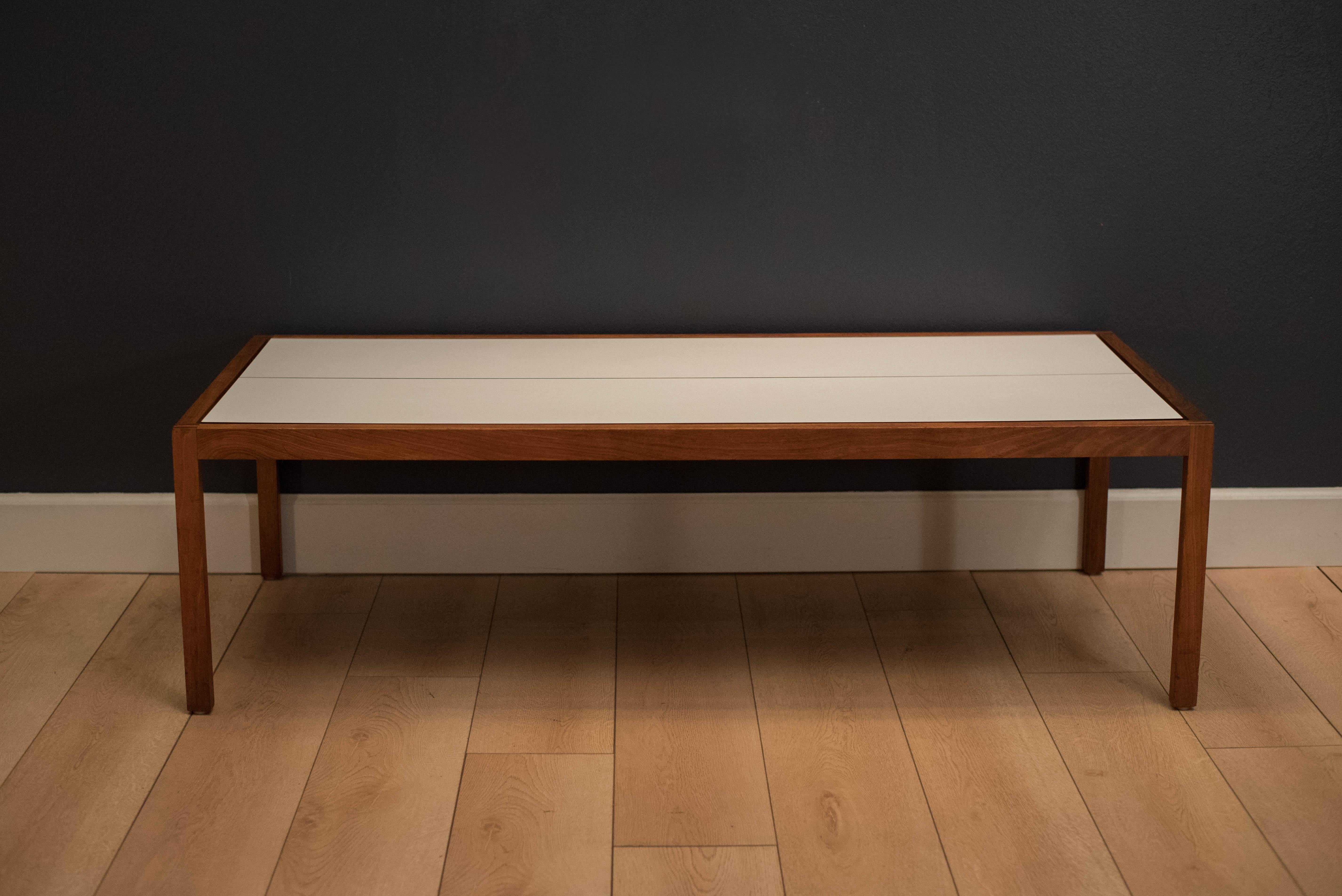Mid century coffee table table designed by Lewis Butler for Knoll. This piece features a floating white laminate top with a rectangular walnut frame.