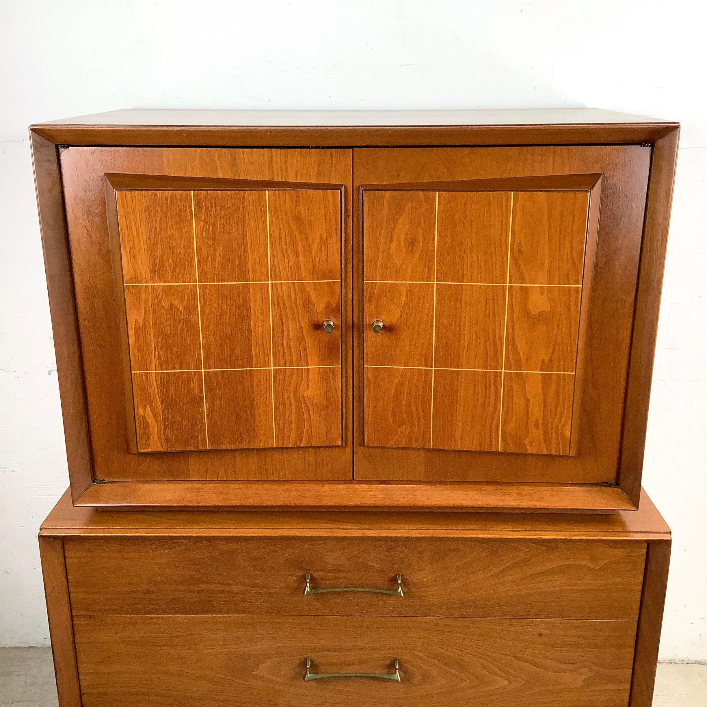 Le linee pulite, il calore del legno e l'attenzione per il contenimento fanno di questo highboy di metà secolo un aggiornamento semplice per qualsiasi stanza. Il mobile superiore presenta una coppia di ante a pannelli con un morbido motivo