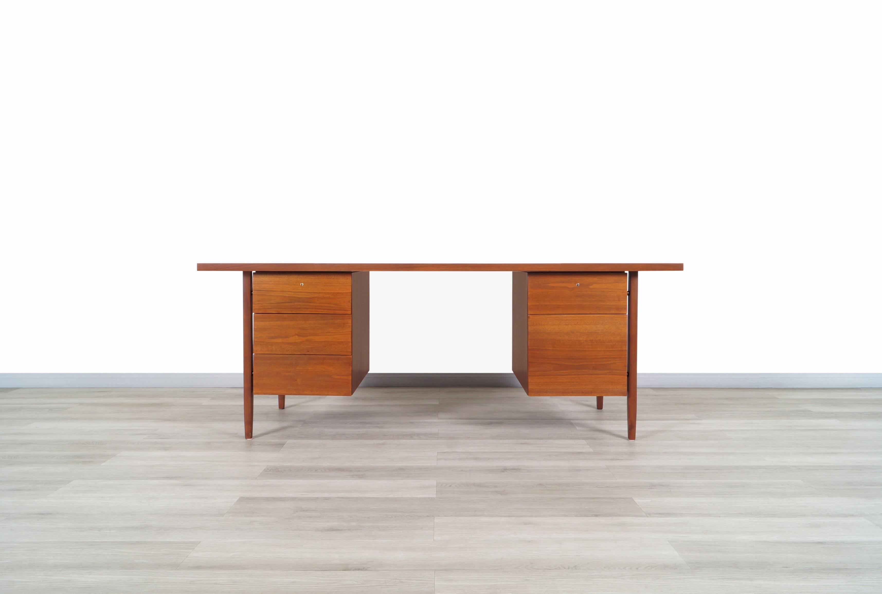 Exceptional vintage walnut executive desk designed by Florence Knoll for Knoll Associates Inc. in the United States, circa 1950s. This stunning desk, also known as model-1503, is made of walnut and features two rectangular cases that look like