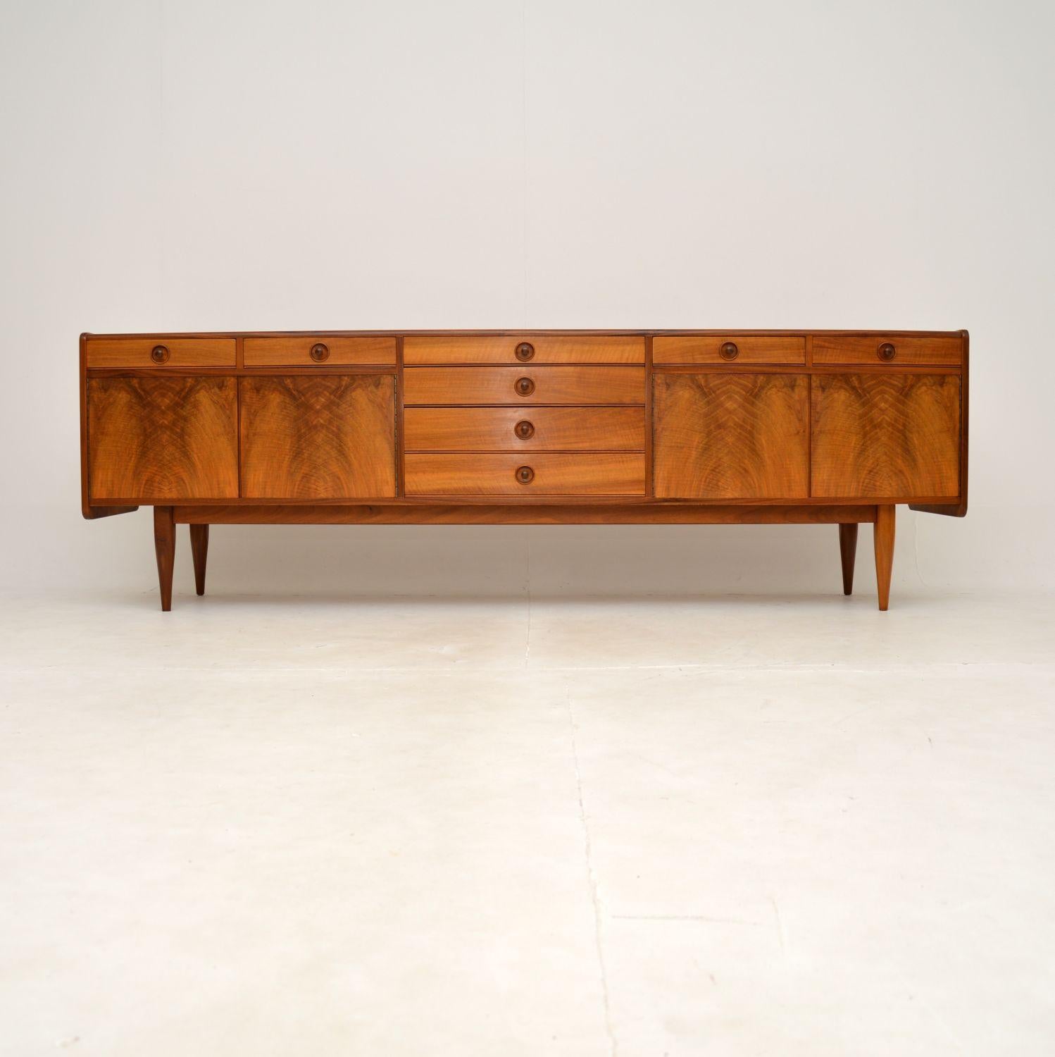 A magnificent vintage walnut sideboard designed by Robert Heritage. This was made in England, it dates from the 1960’s.

The quality of this is absolutely outstanding, it is extremely well made and beautifully designed. There are four doors and two