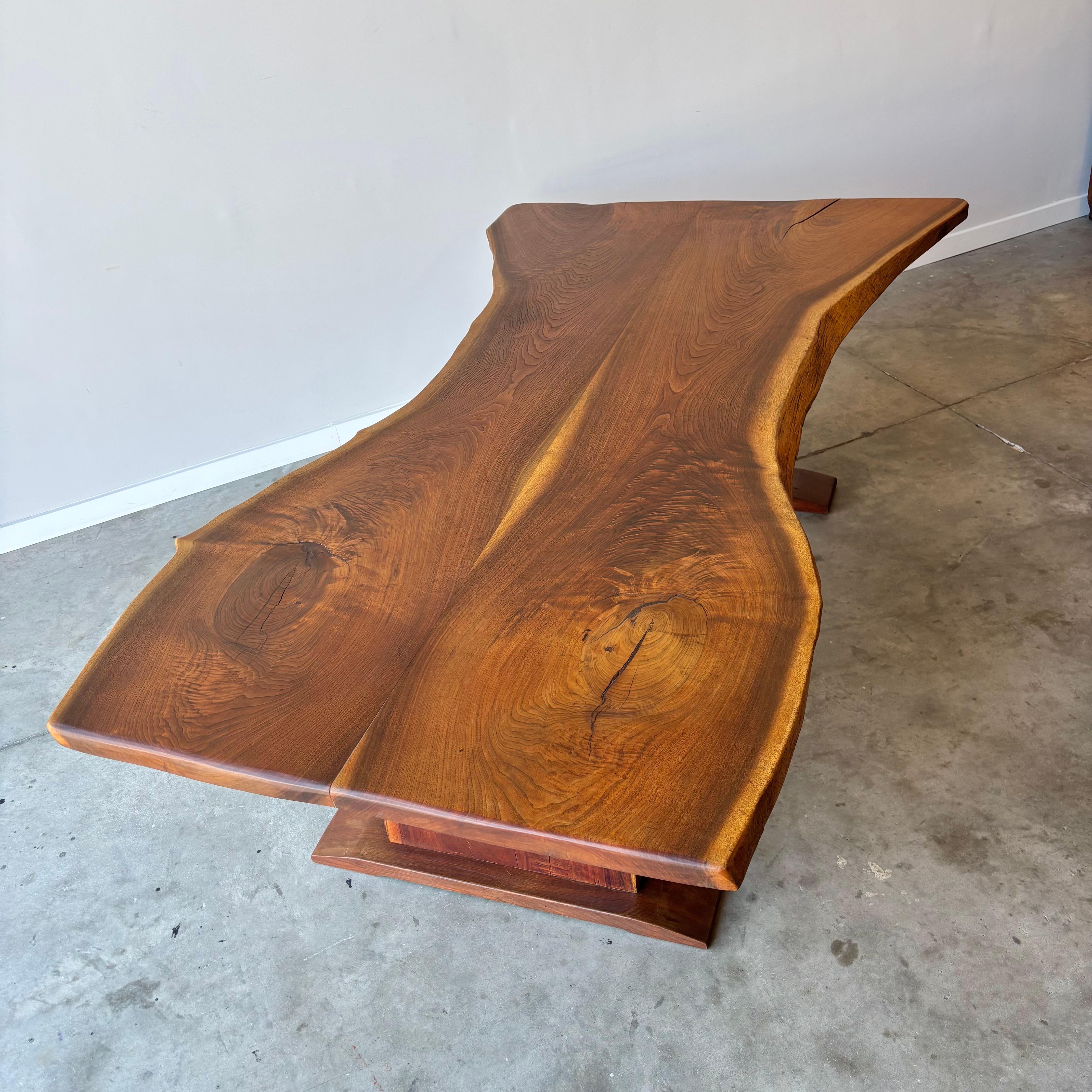 A striking vintage live edge table with butterfly matched slab top and trestle leg base.  Constructed of solid walnut with 2