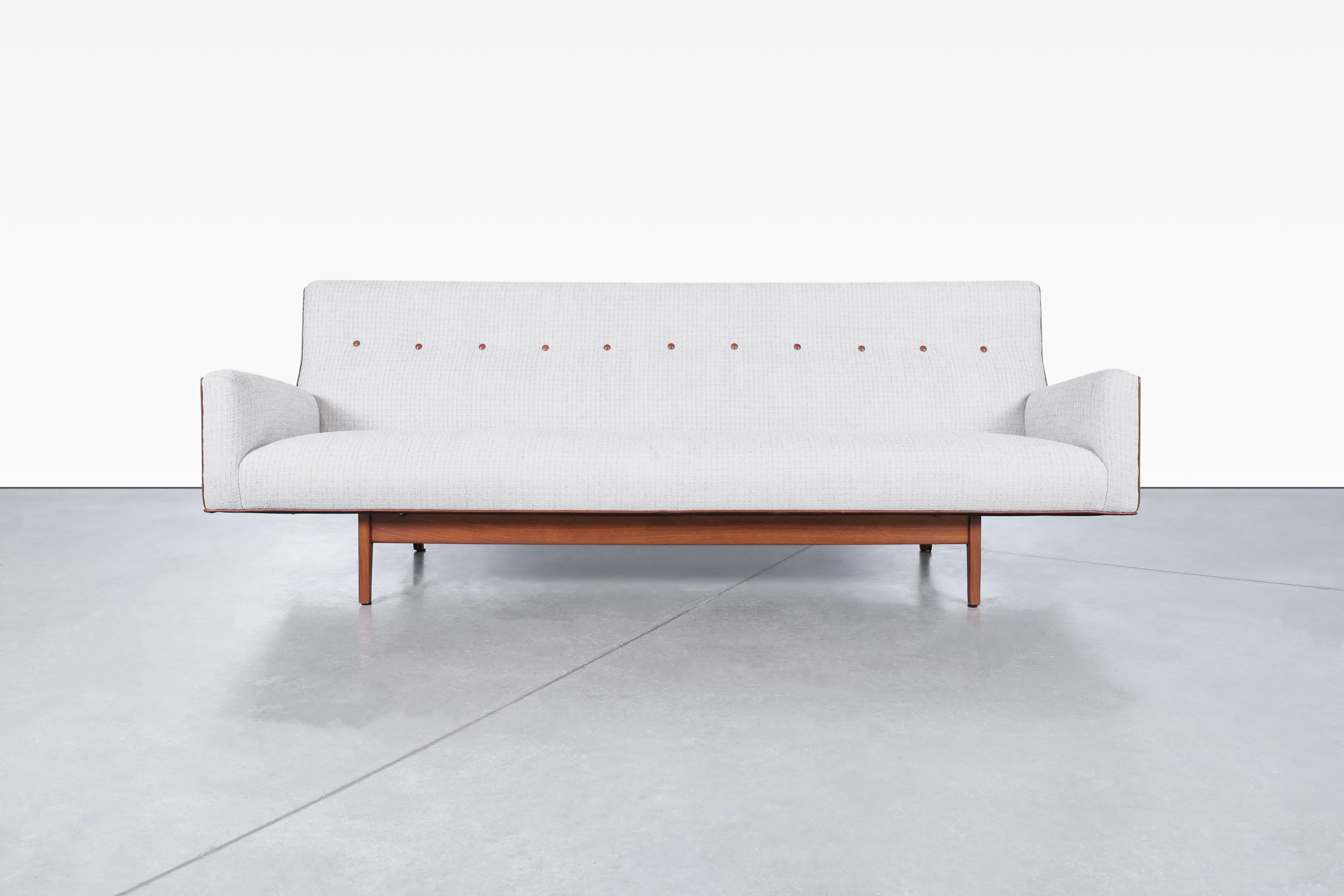 Vintage walnut sofa designed by the iconic designer Jens Risom in the United States, circa 1950s. Transform your living space with this exquisitely refinished and reupholstered classic design piece. The combination of rich walnut, plush chenille
