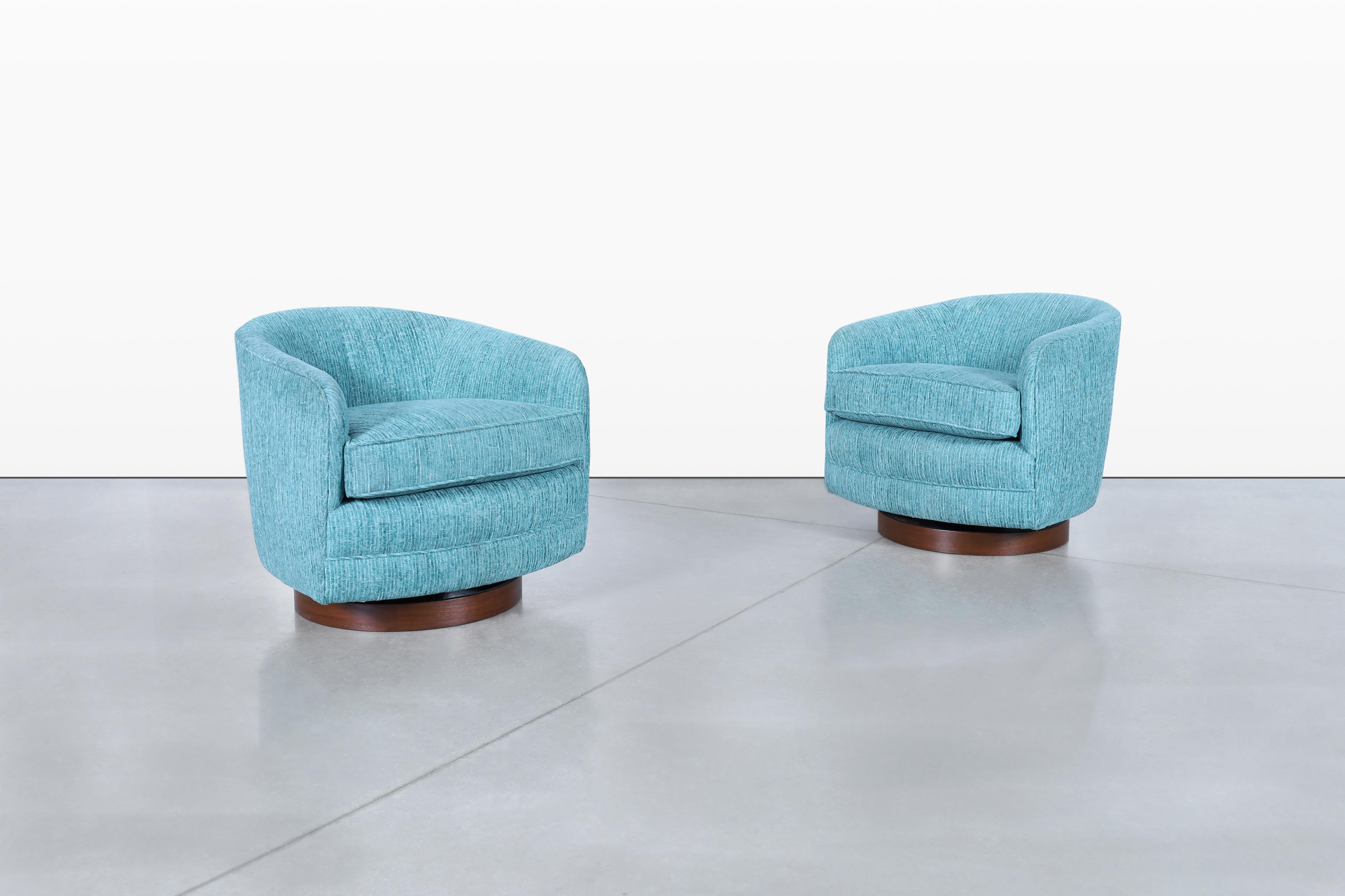 Imagine adding a touch of mid-century elegance to your space with these stunning vintage walnut swivel lounge chairs, expertly designed by Milo Baughman for Thayer Coggin, dating back to the 1960s. Their unique barrel-shaped design offers both