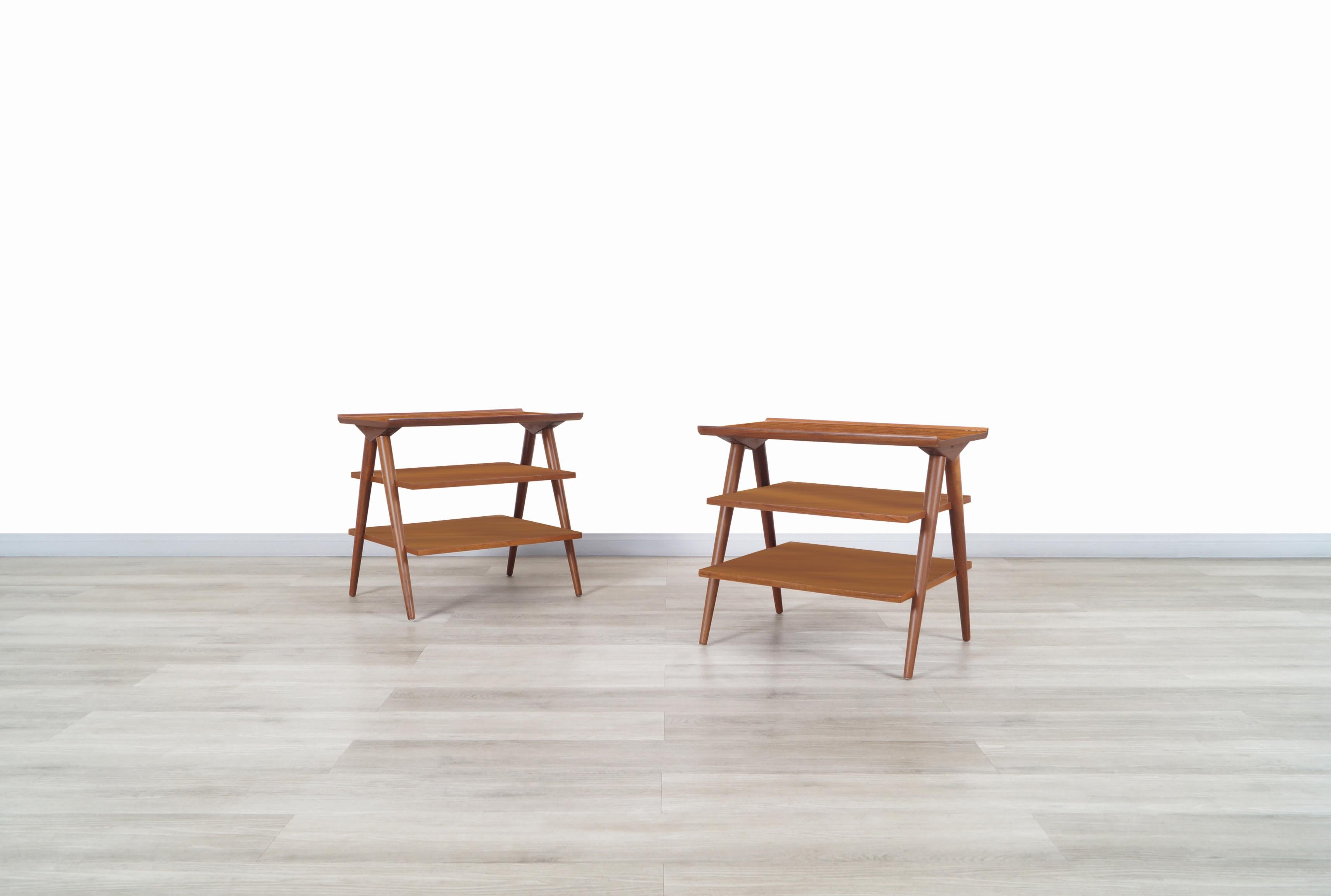Stunning vintage three-tiered walnut tables designed by Merton L. Gershun for American of Martinsville in the United States, circa 1950s. These three-tiered tables have an avant-garde design where the fine walnut wood stands out throughout its