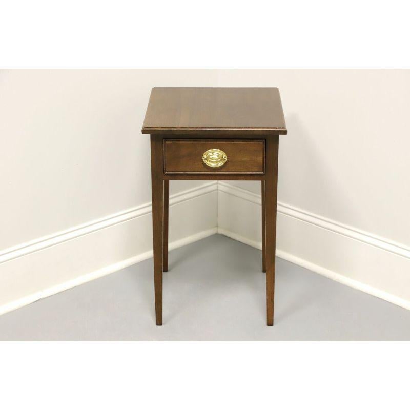 A Traditional style accent table by Waterford Furniture Makers of Lynchburg, Virginia, USA. Walnut with brass hardware. Features one dovetail drawer and tapered straight legs. Made in the mid 20th Century.

Measures: 15.5 W 17 D 24.25