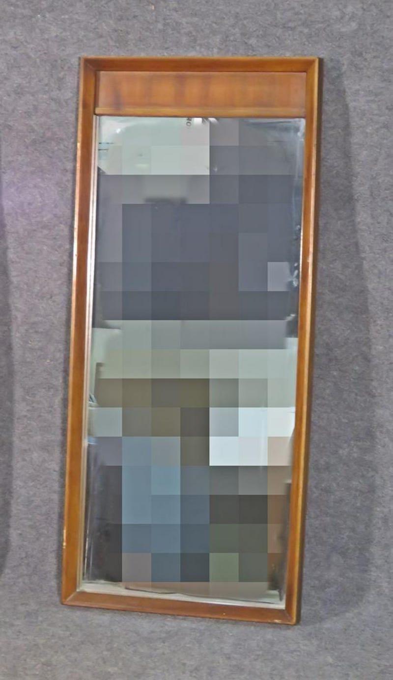 Elegant wall mirror by American of Martinsville, showing off a rich walnut woodgrain and Mid-Century design. Please confirm item location with seller (NY/NJ).