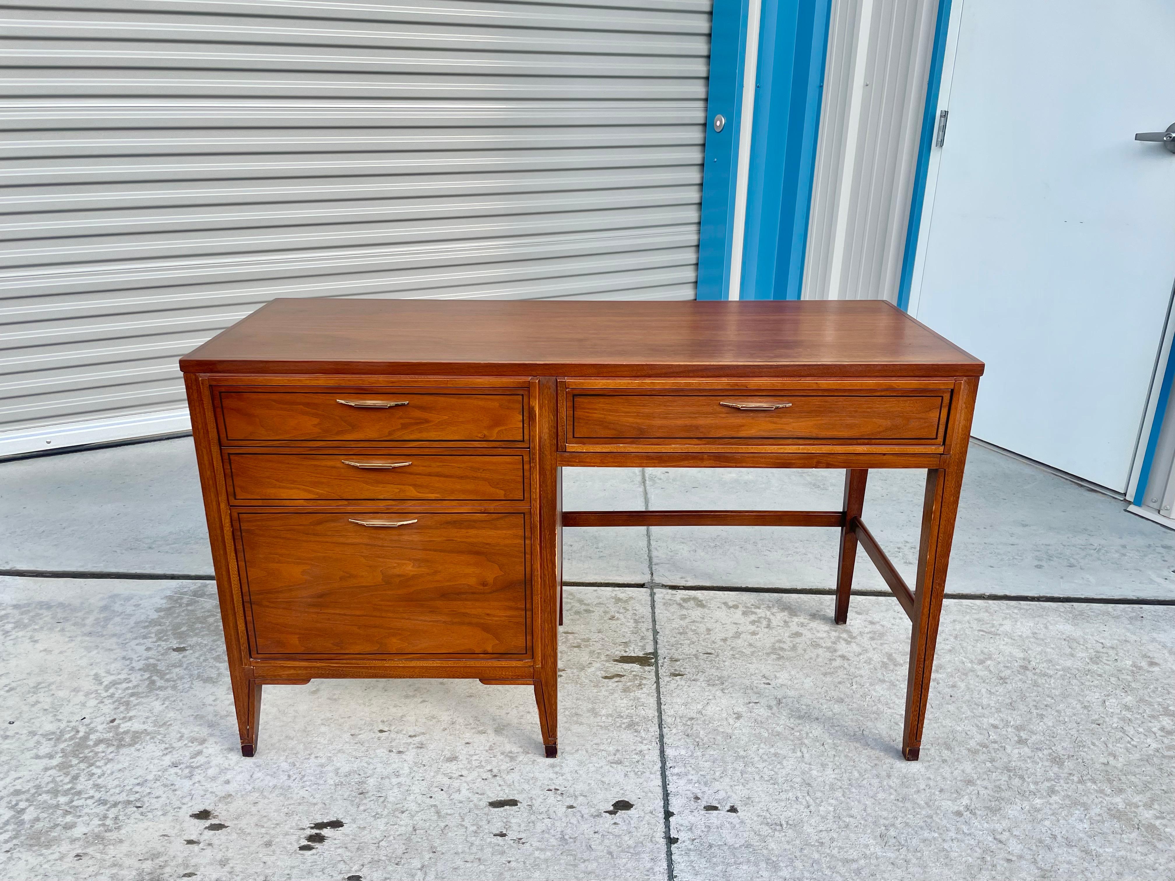 This unique walnut writing desk was designed and manufactured by Kent Coffey Tempo in the United States circa 1960. the vintage writing desk features four drawers giving you plenty of storage space for all your office needs. Each drawer features a