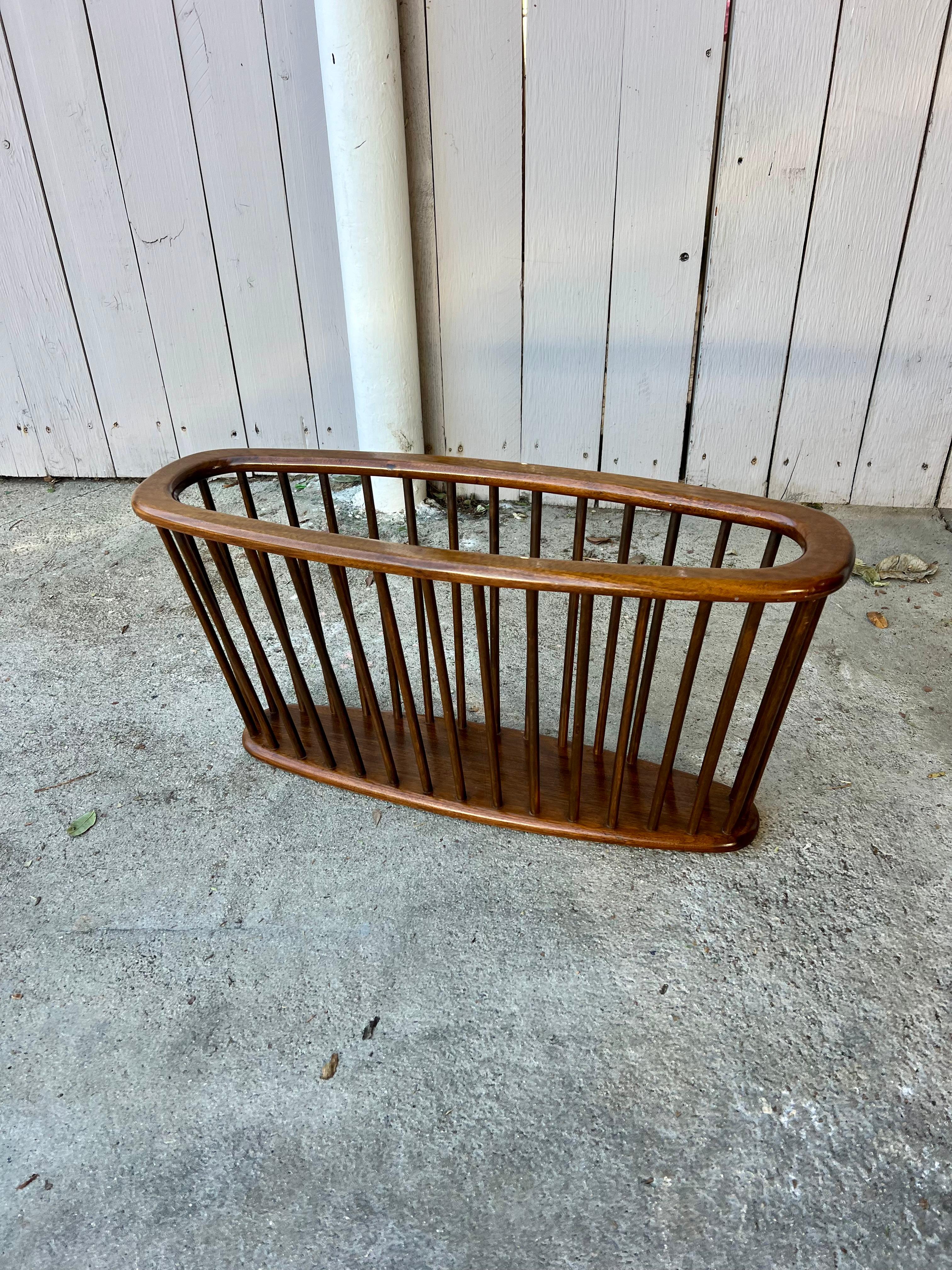 This large mid century modern spindle magazine rack is the spitting image of an Arther Umanoff original. This handsome rack is a “Big Boy” measuring in at just under 30″ in length. The deep brown patina of the walnut is chefs kiss. If it wasn’t