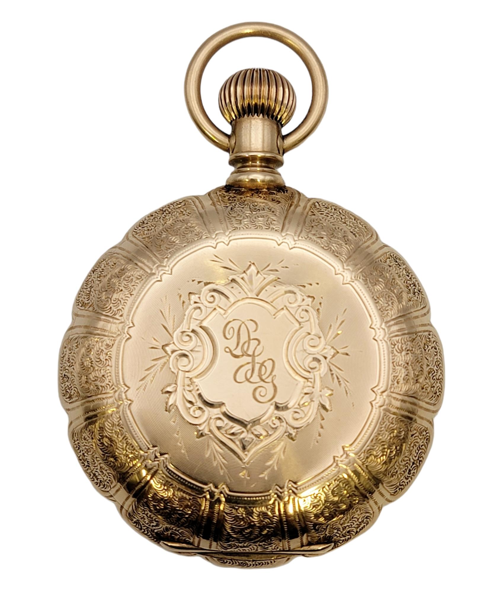 This rare vintage 14 karat yellow gold pocket watch by Waltham is a stunning piece of history. The luxury solid gold timepiece is made with exquisite fine details. It features a 46mm case with a round white dial, black Roman Numeral hour markers and