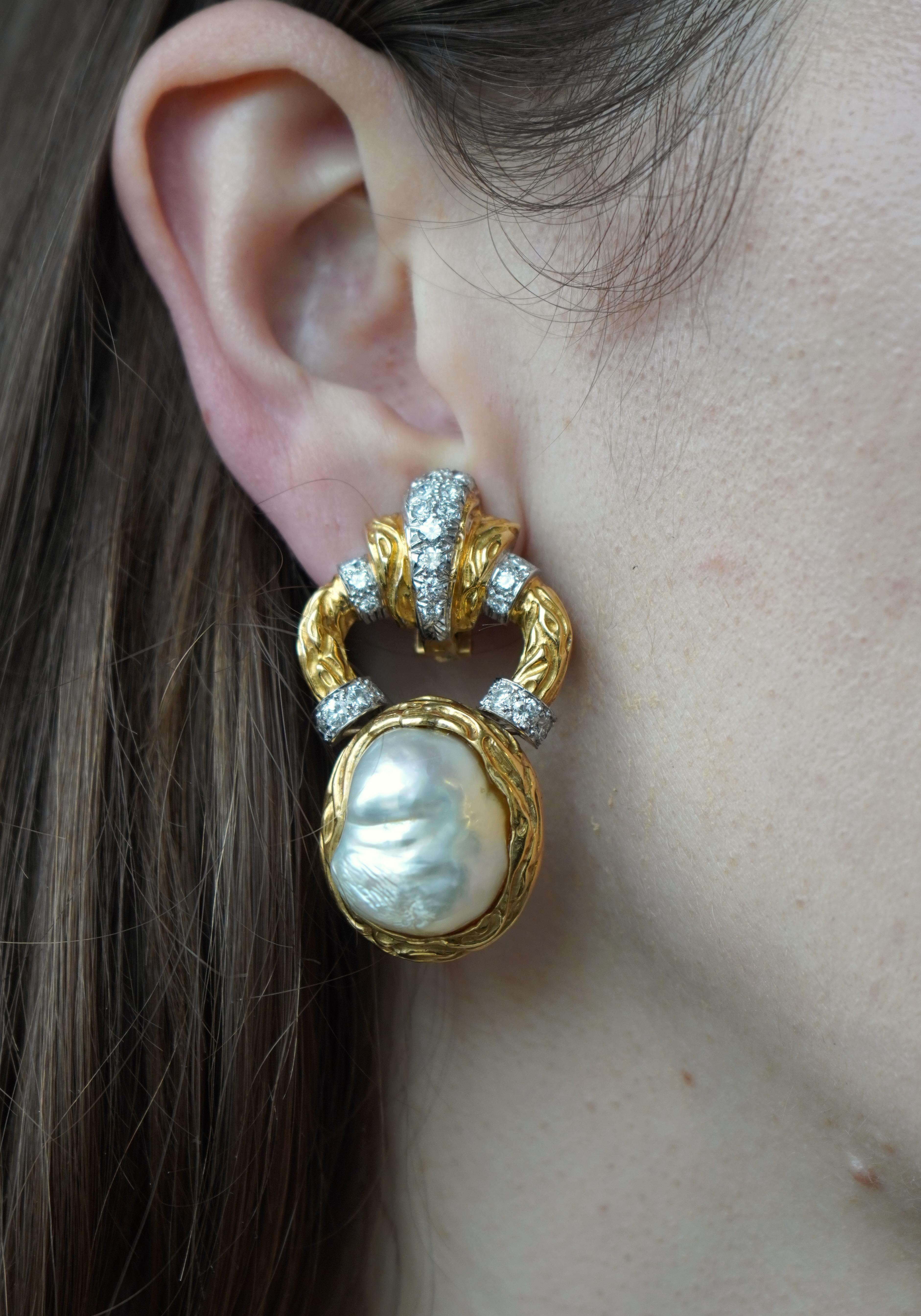 Dieses Paar Vintage-Ohrringe von Wander ist aus zweifarbigem 18-karätigem Gold gefertigt und zeigt Barockperlen in skulpturalen Fassungen. Der obere Teil zeigt ein strukturiertes goldenes Schneckenmuster, das mit runden, in Weißgold gefassten