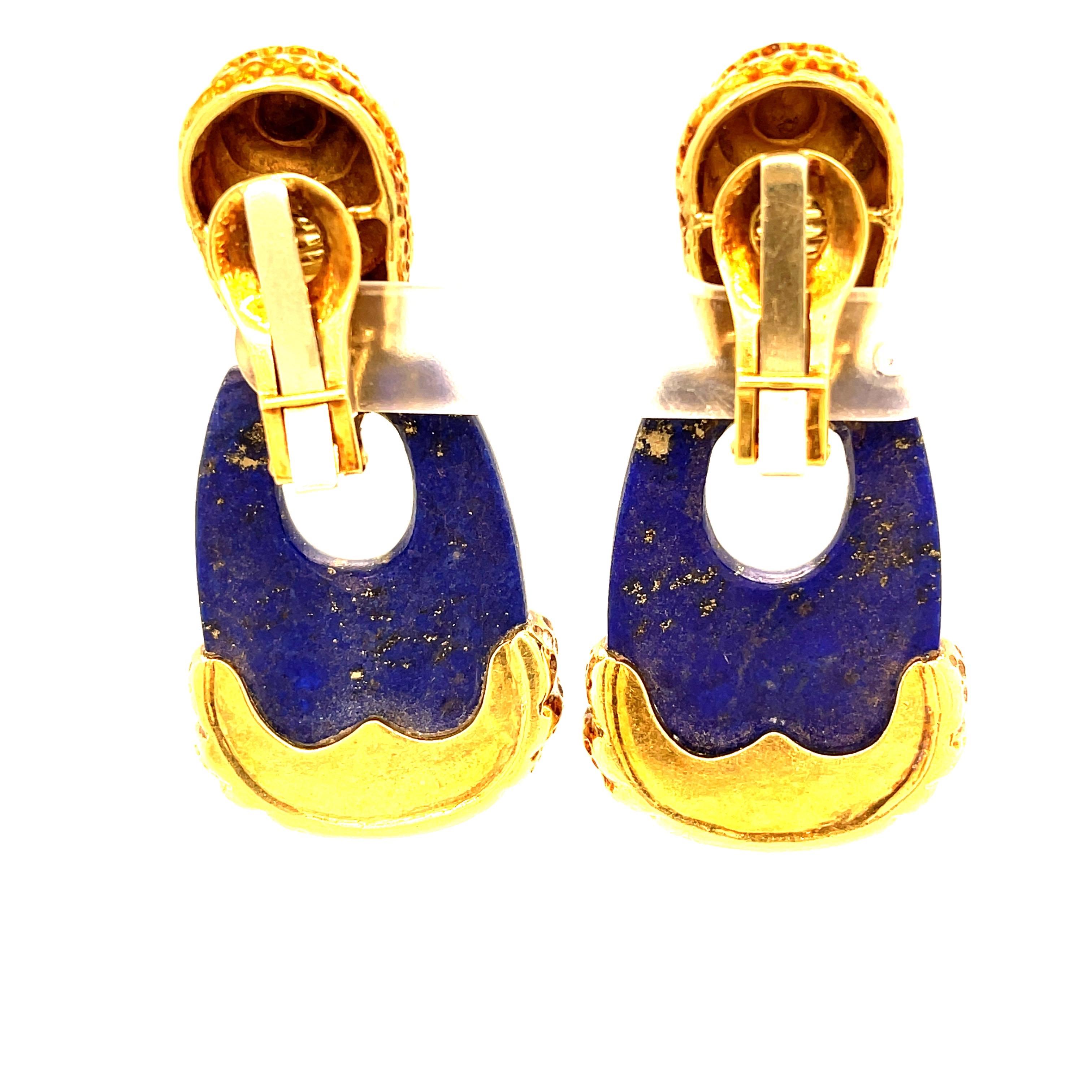 A fun pair of vintage 18k gold lapis doorknocker earrings by Wander. Wander was a French jeweler in the mid 20th Century who is known for his bold designs and now very 1970s aesthetic. These earrings have textured fluted gold parts surrounding a