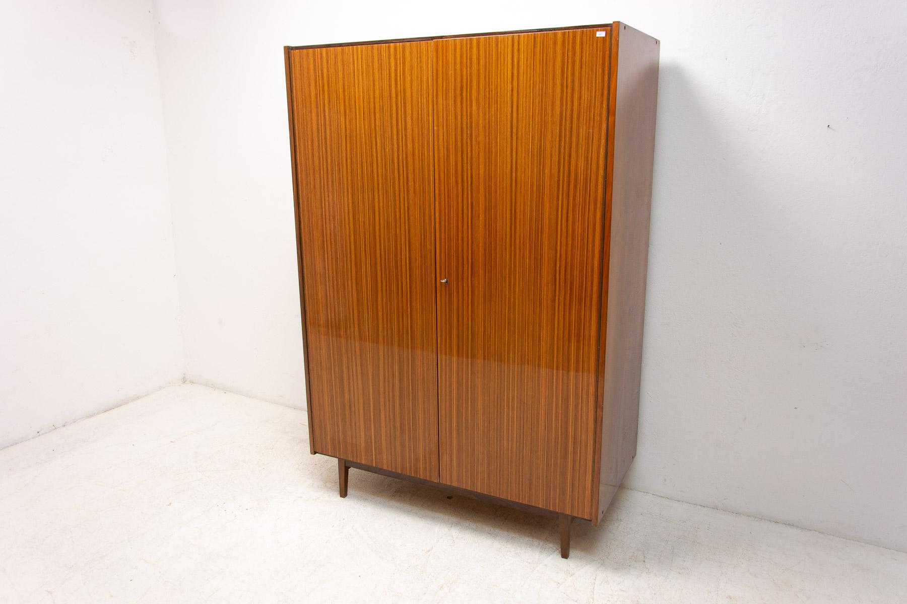 Vintage Czechoslovak wardrobe, made in the 1970´s in the former Czechoslovakia. Made by Interiér Praha company.

It´s made of plywood, glossy mahogany veneer, beech wood legs.

The left side with shelves and two drawers, on the right there is
