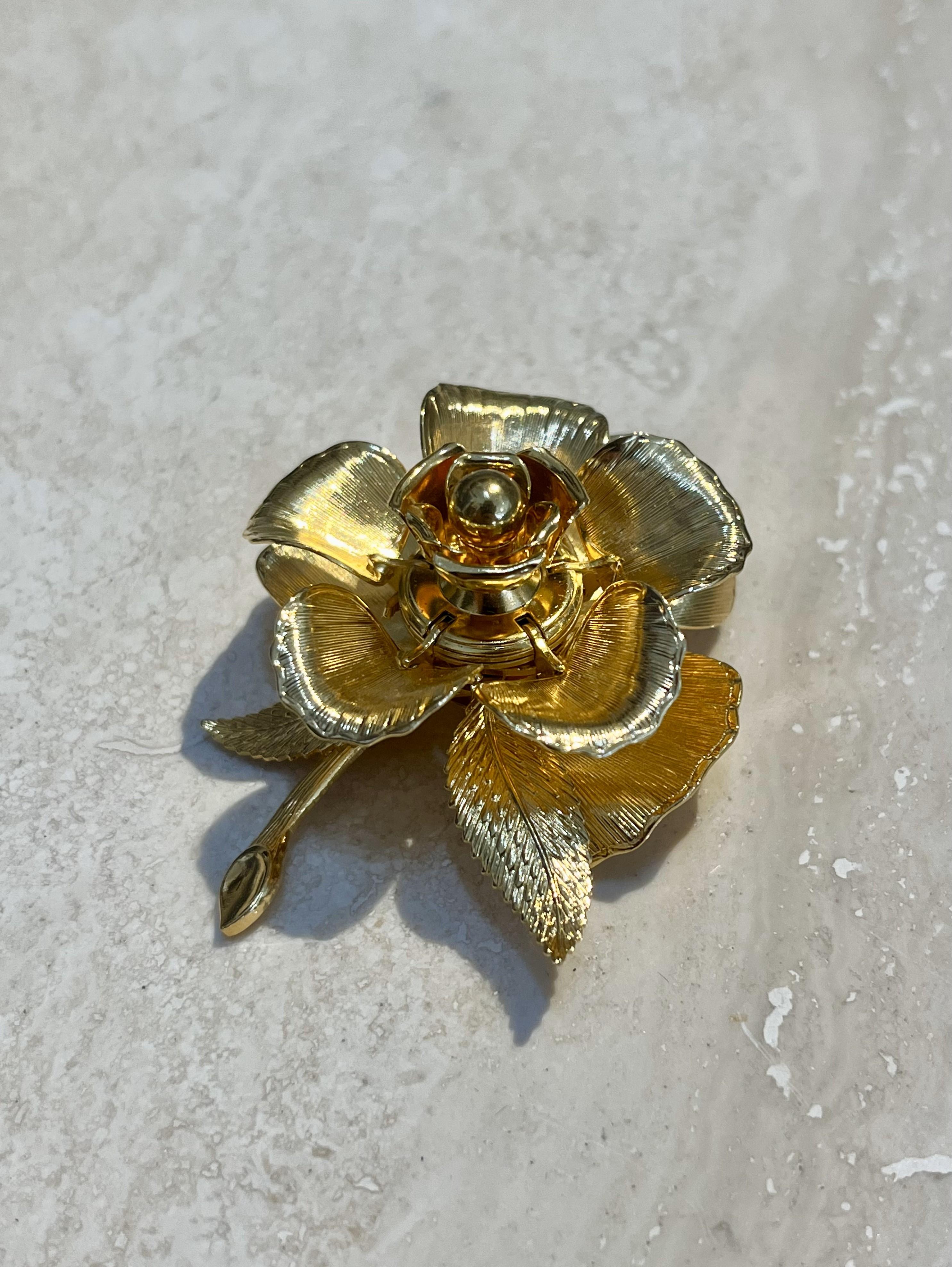 This Vintage Warner Day & Night Gold Plated Floral Brooch is a beautiful and versatile piece of jewelry, combining the intricate artistry of floral design with the practicality of day-to-night wear. Warner was known for creating high-quality costume