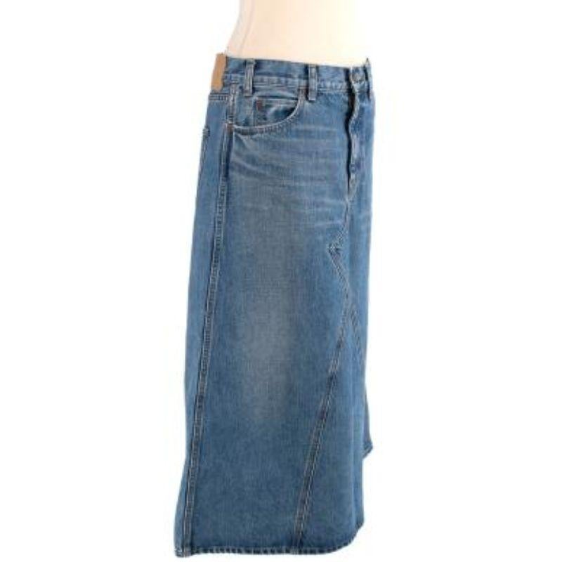 Celine Vintage Wash Denim Skirt
 
 - Mid length, blue wash denim skirt with light brown contrast stitching 
 - Crossover hem detailing 
 - Bronze tone rivets and zip at the fly
 - Pockets on each side at the front and back
 
 Materials
 100% Cotton