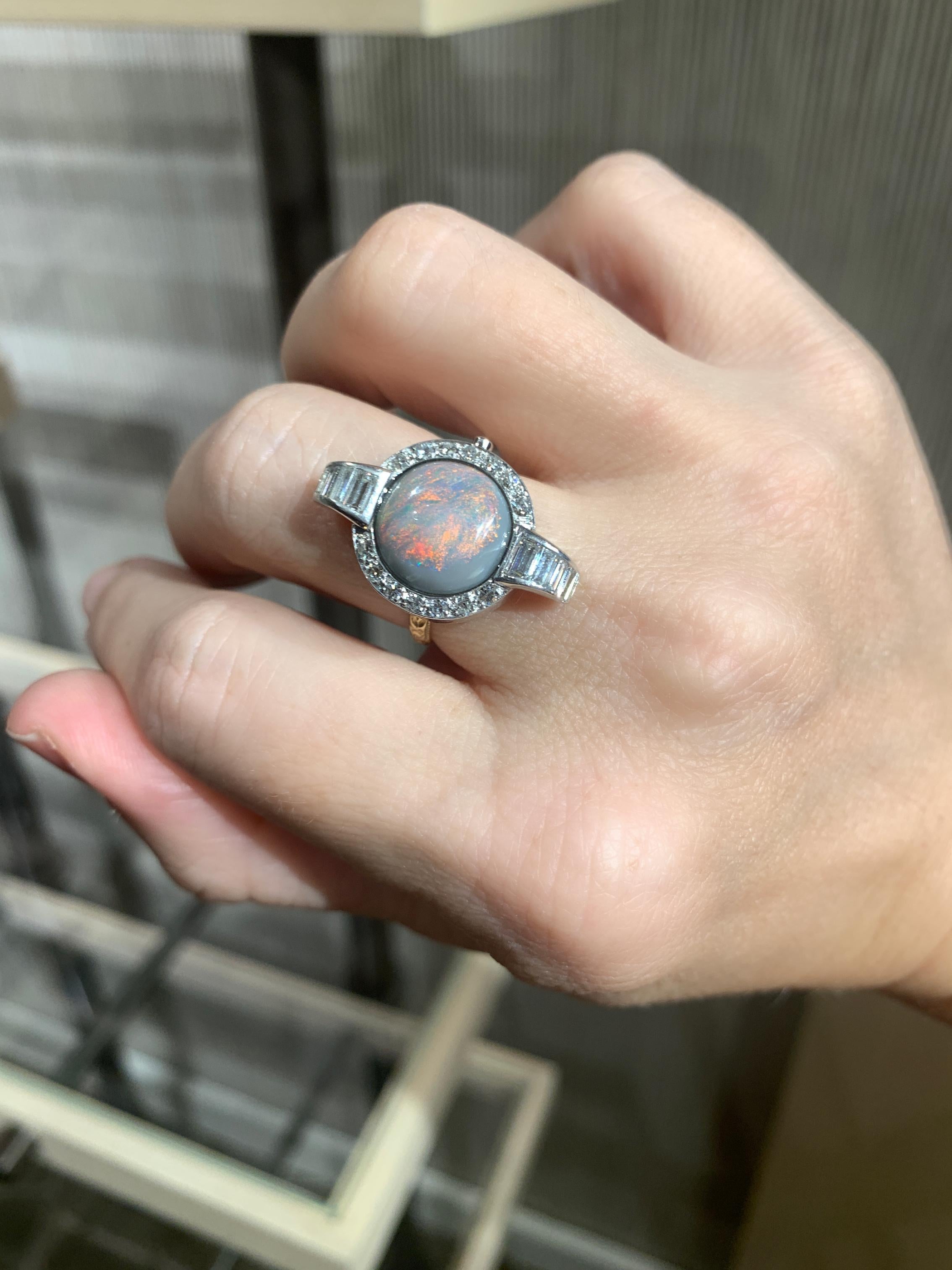 Anillo único de la diseñadora de joyas Julie Romanenko (Just Jules) que muestra un magnífico cabujón redondo de ópalo australiano natural de color violeta con fuego primario rojo y verde, engastado en bisel en una caja de reloj vintage de platino