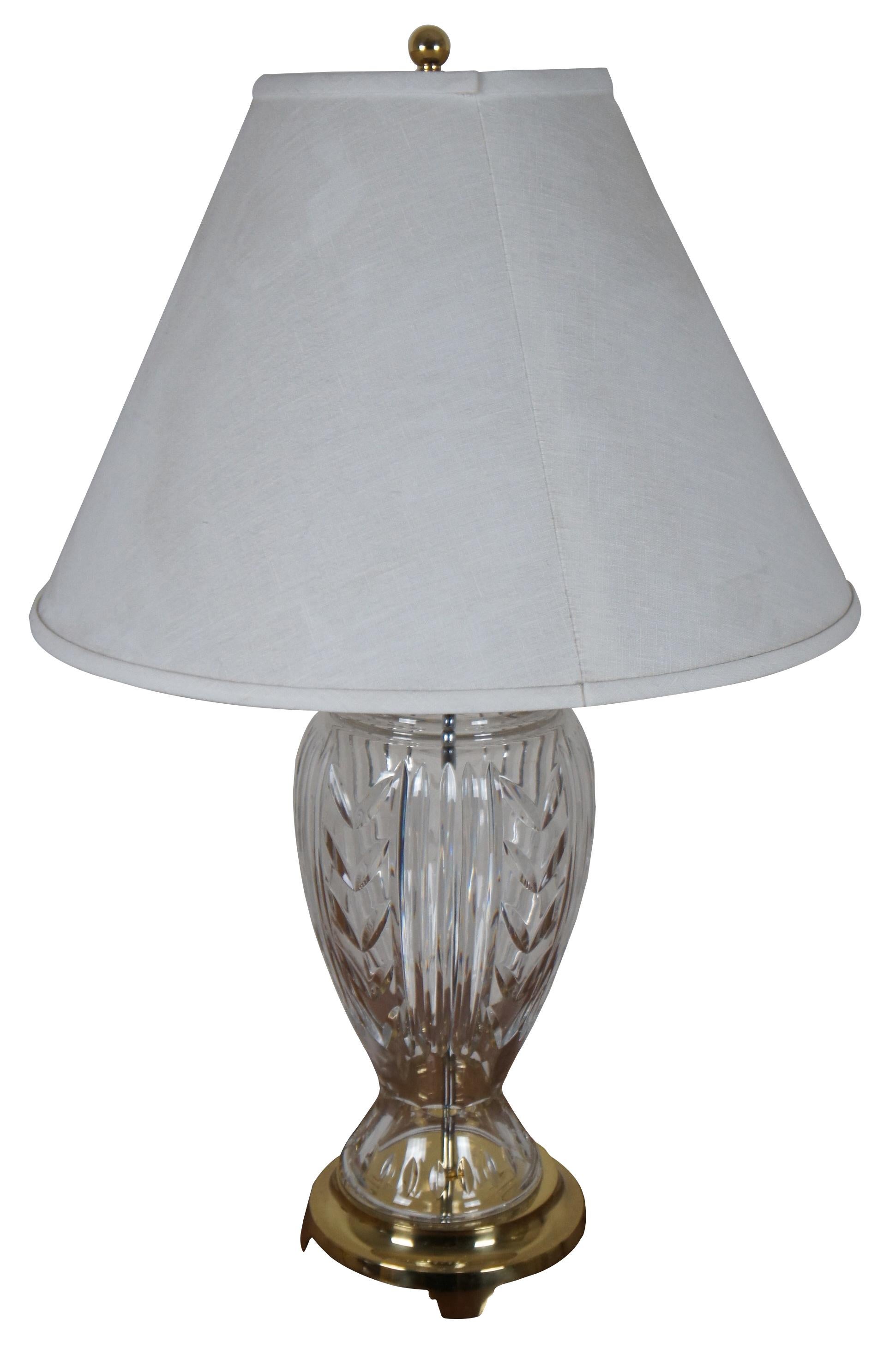 Vintage Hollywood Regency Waterford Irish cut crystal table lamp in the Glencar pattern with brass base and top, and a white shade.

Measures: 7.5” x 24” / shade - 20” x 14” / height to top of finial – 32” (diameter x height).
 