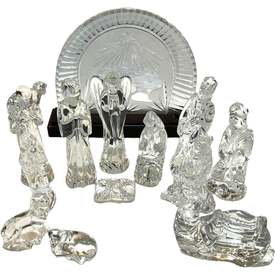 This stunning Waterford 12pc + backdrop set is a must-have for collectors and lovers of vintage decor.  Crafted by Waterford, a renowned crystal manufacturer from Ireland, this set features large figurines of Mary, Joseph, Baby Jesus, Angel, 3 Wise