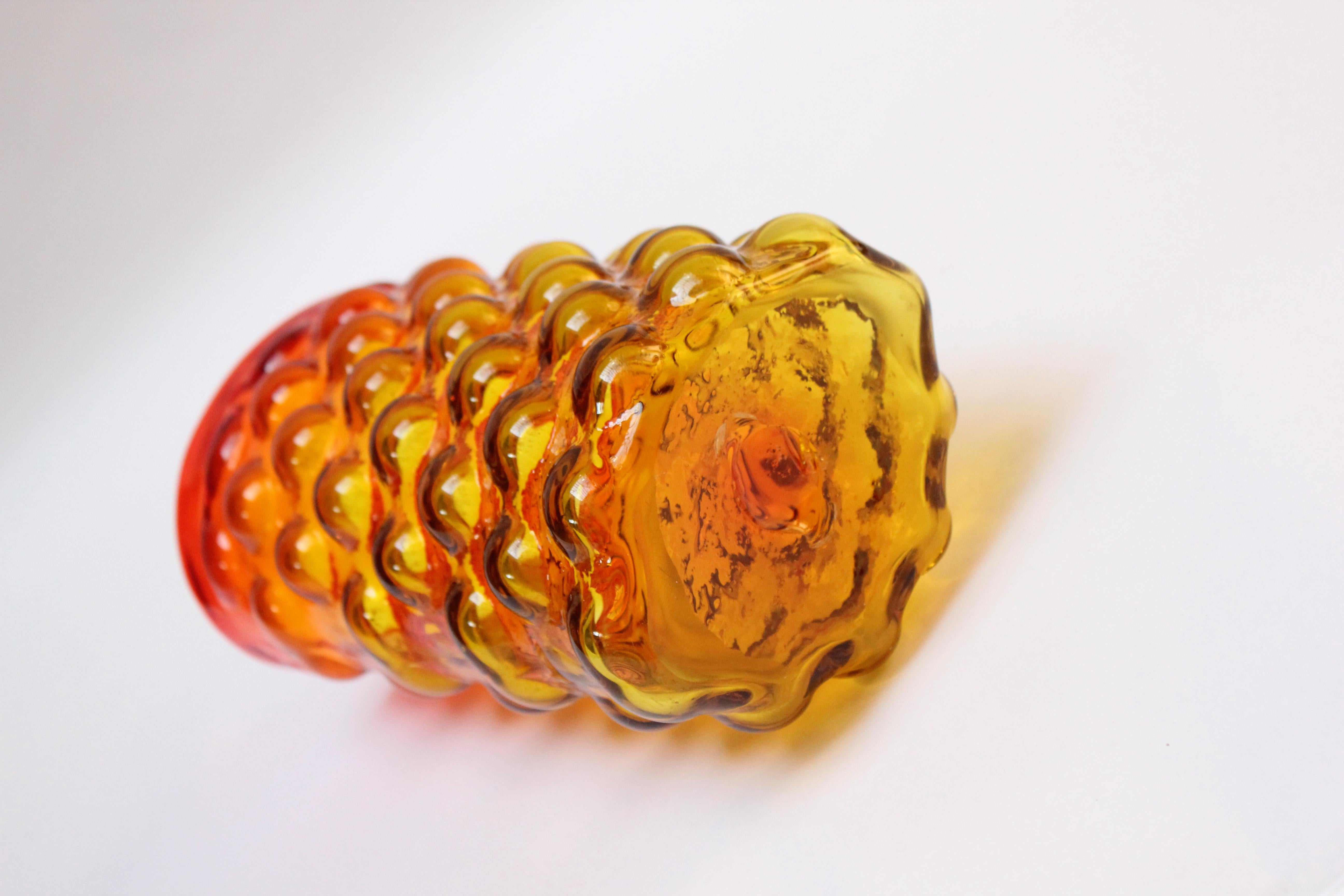 Blown glass vase designed in 1961 by Wayne Husted for Blenko (model number 6041). Attractive 'bubble' pattern throughout and brilliant amberina / tangerine palette with red and yellow meeting to produce an orange banding toward the top.
Features