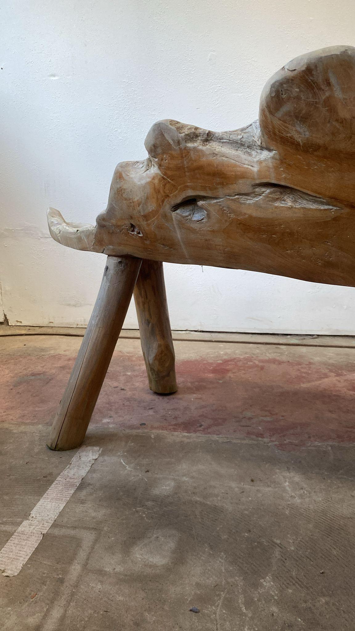 An organic form teak root bench naturally weathered by the sun and weather. Its organic asymmetrical shaped back lead to a wide curved seat. It sits on strong legs. 

On trend for any space that requires an organic and natural punctuation in the