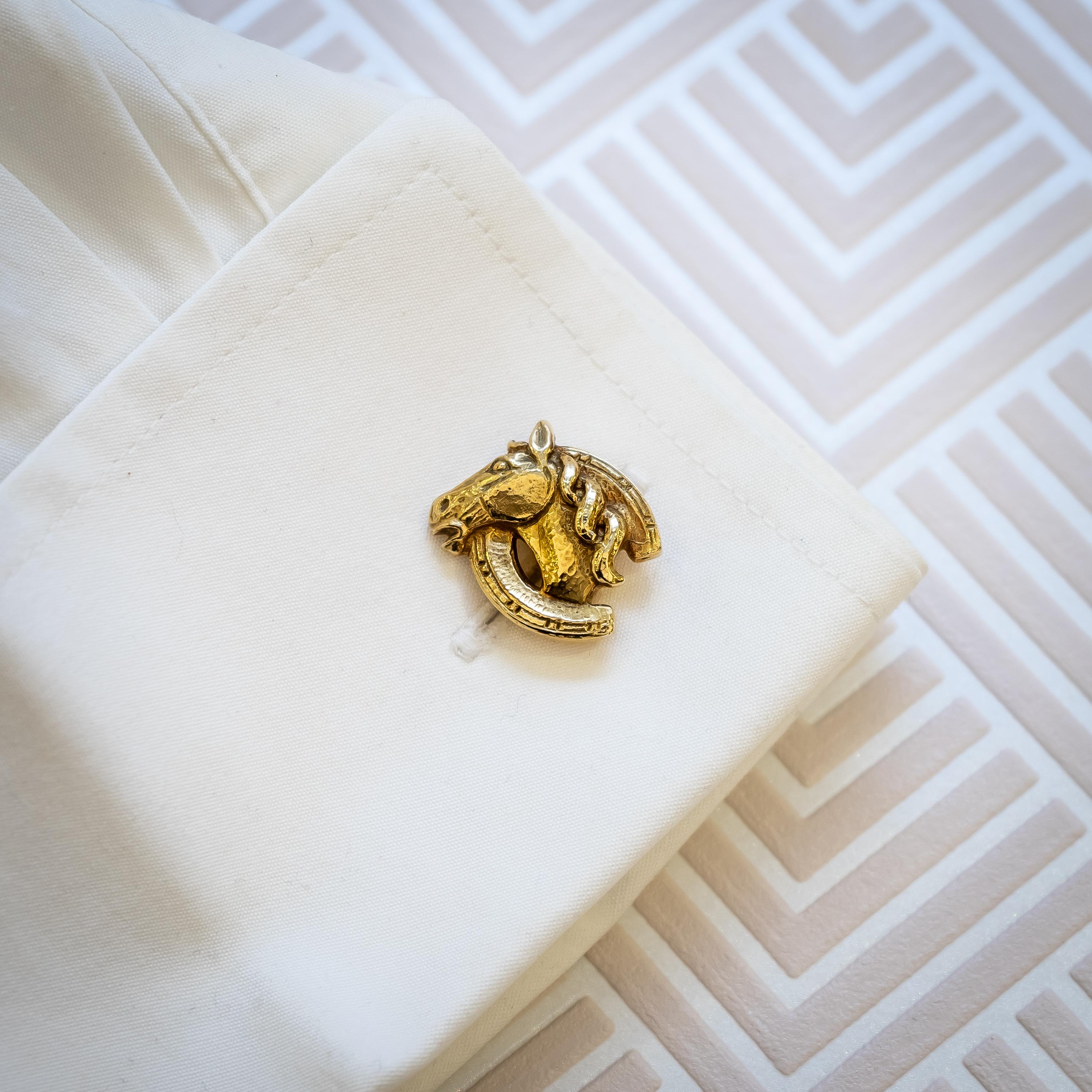A pair of vintage gold horse cufflinks, by Webb, with horse heads surmounted on horseshoes, with nails as bars. Signed Webb. Circa 1960.