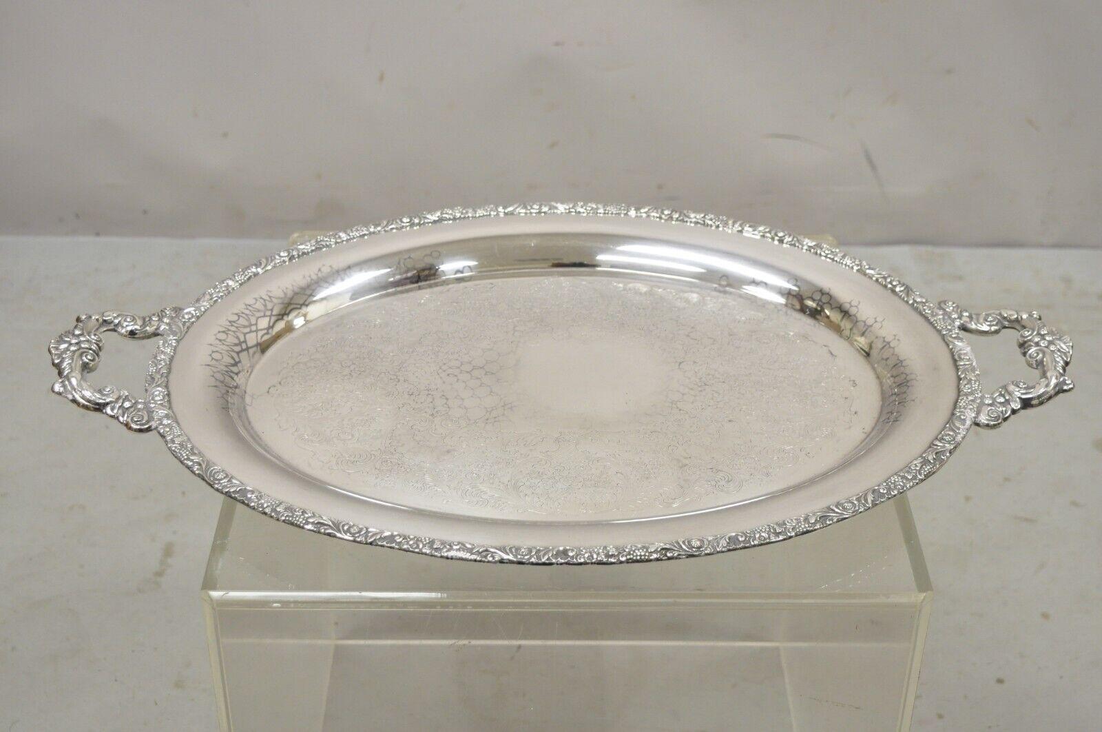 Vintage Webster Wilcox International Silver Co. silver plated oval twin handle platter tray. Item features ornate twin handles, oval shape, ornate etched center, original labels, circa early to mid 1900s. Measurements: 1.5