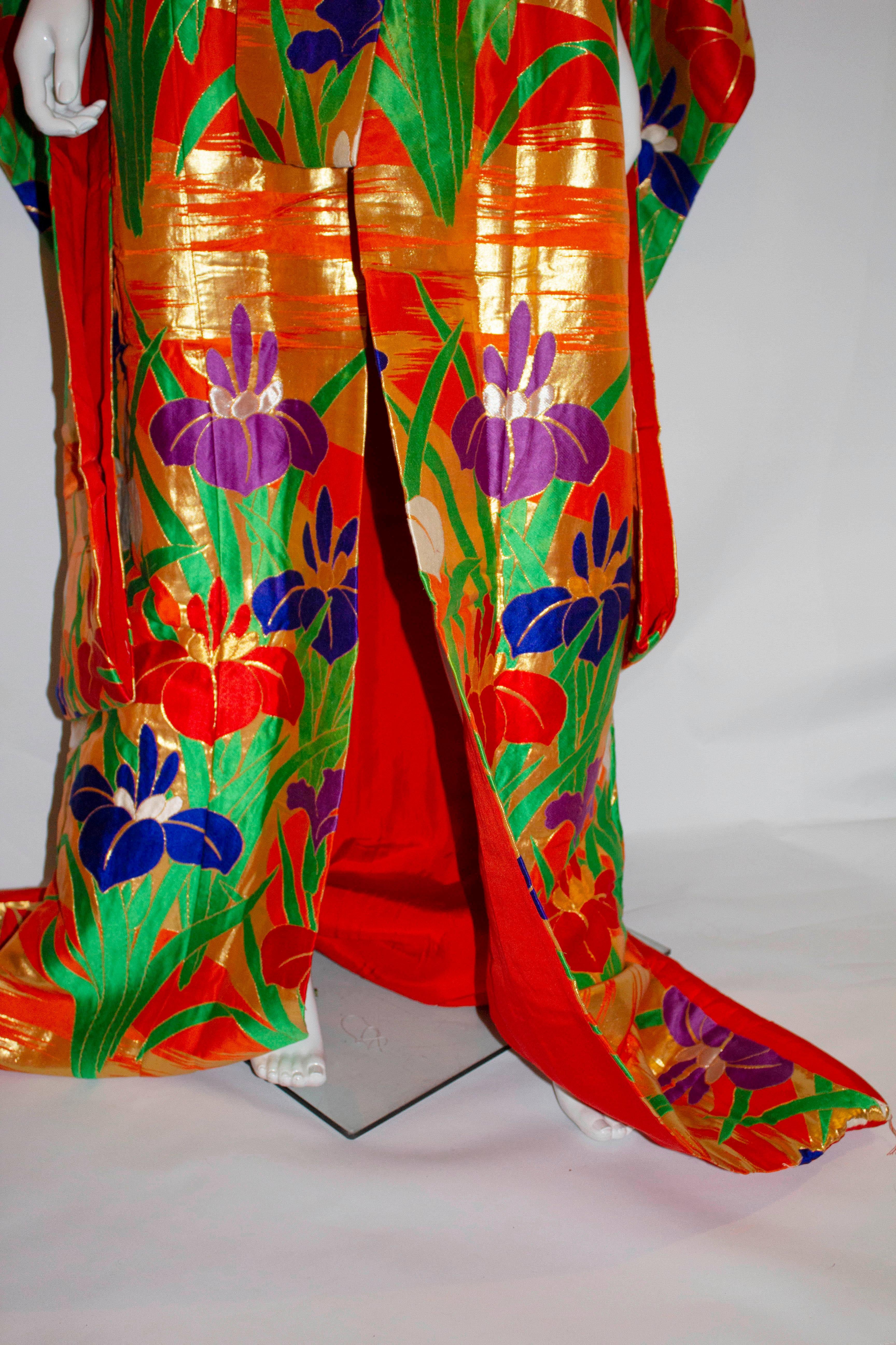 Un exemple rare de kimono en fil rouge et or avec un motif d'iris multicolores... La signification des fleurs est appelée Hanakotoba au Japon, ce qui est lié à l'enseignement bouddhiste d'apprécier le moment transitoire que la beauté d'une fleur
