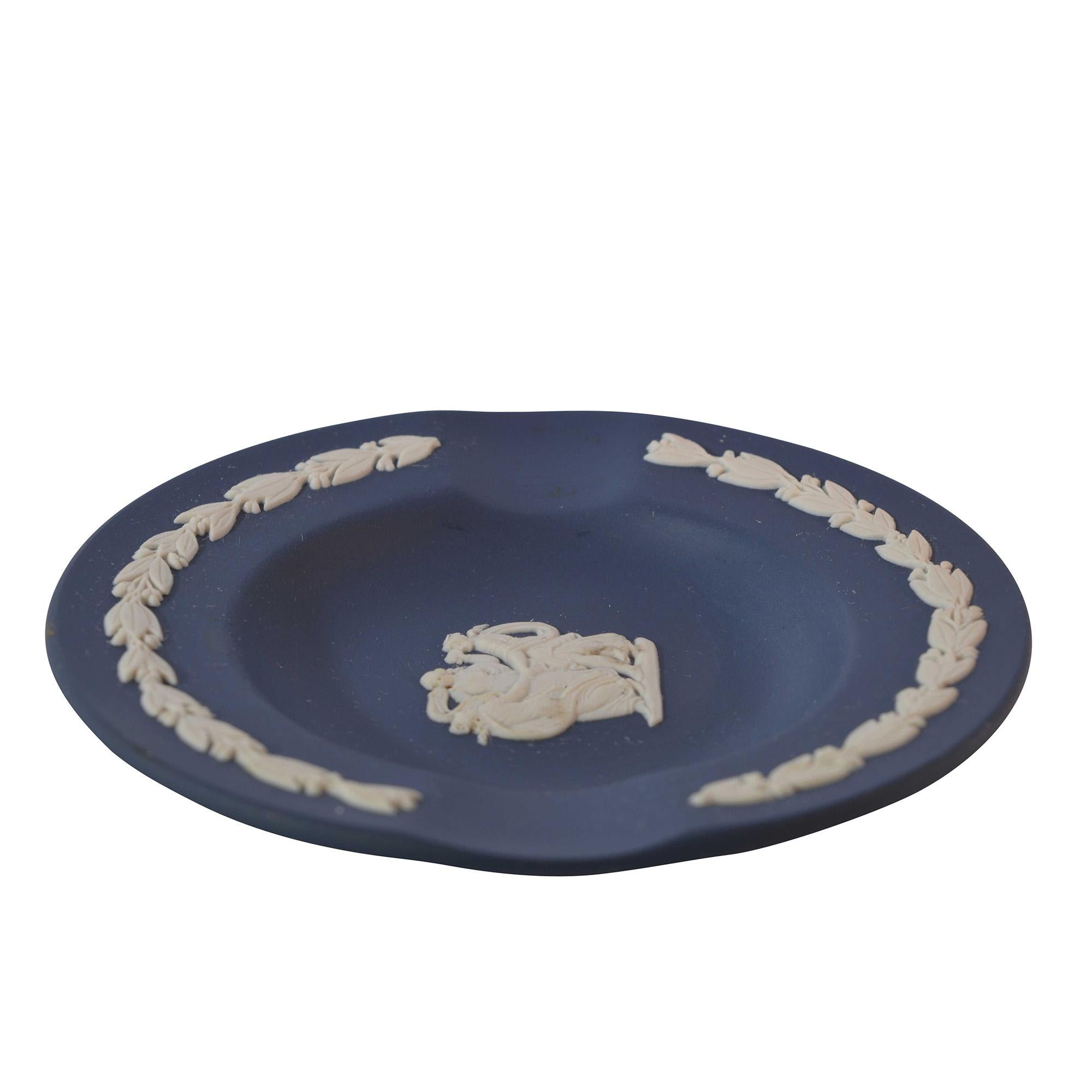 The vintage ashtray features a centre relief design in ivory on a dark blue base. The ivory detail continues around the edge. 

Dimensions: 3.5