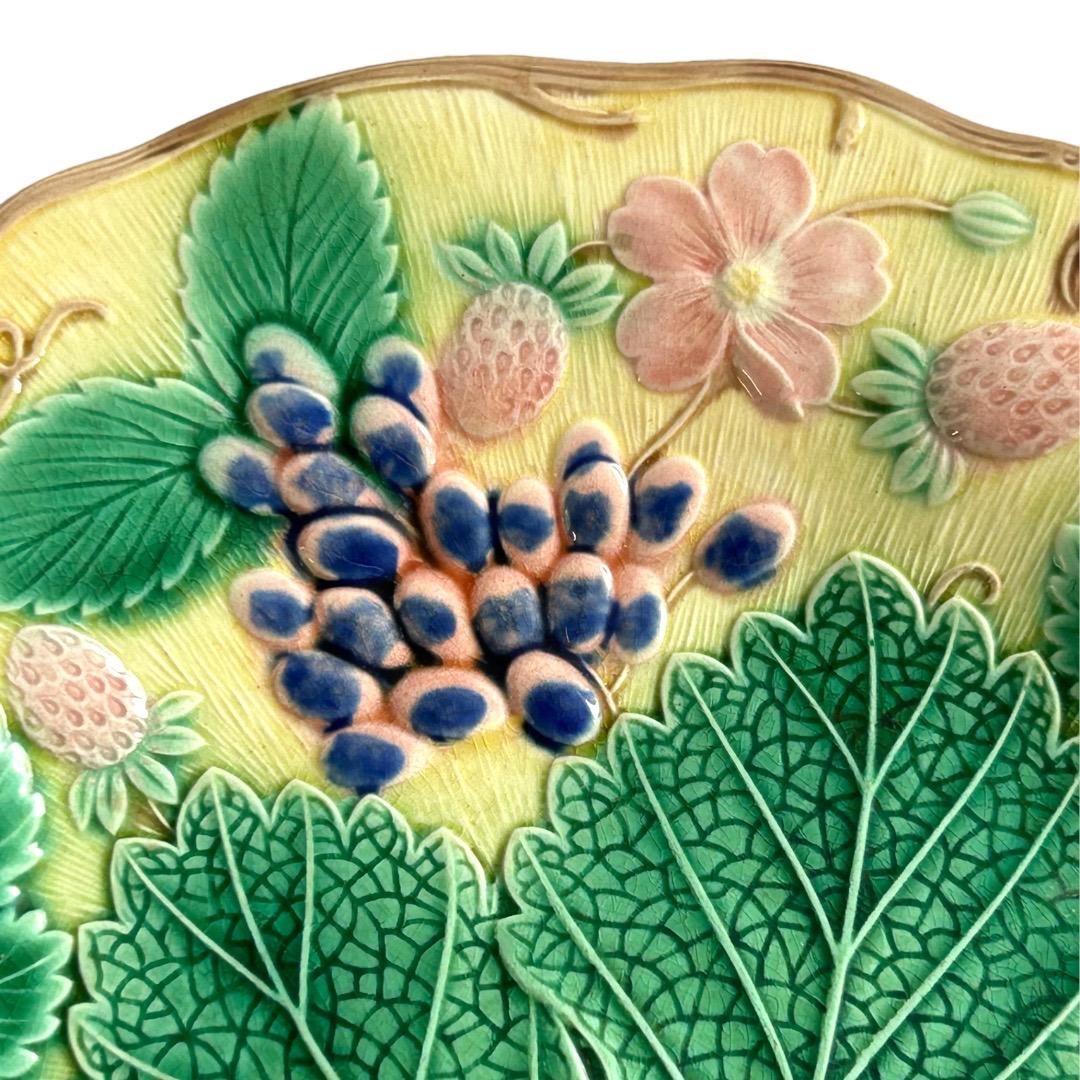 Excellent condition for age ~ no chips, cracks or repairs! yellow plate decorated with leaves, grapes, strawberries and blossoms; marked with “Wedgwood” and Made in England on back.