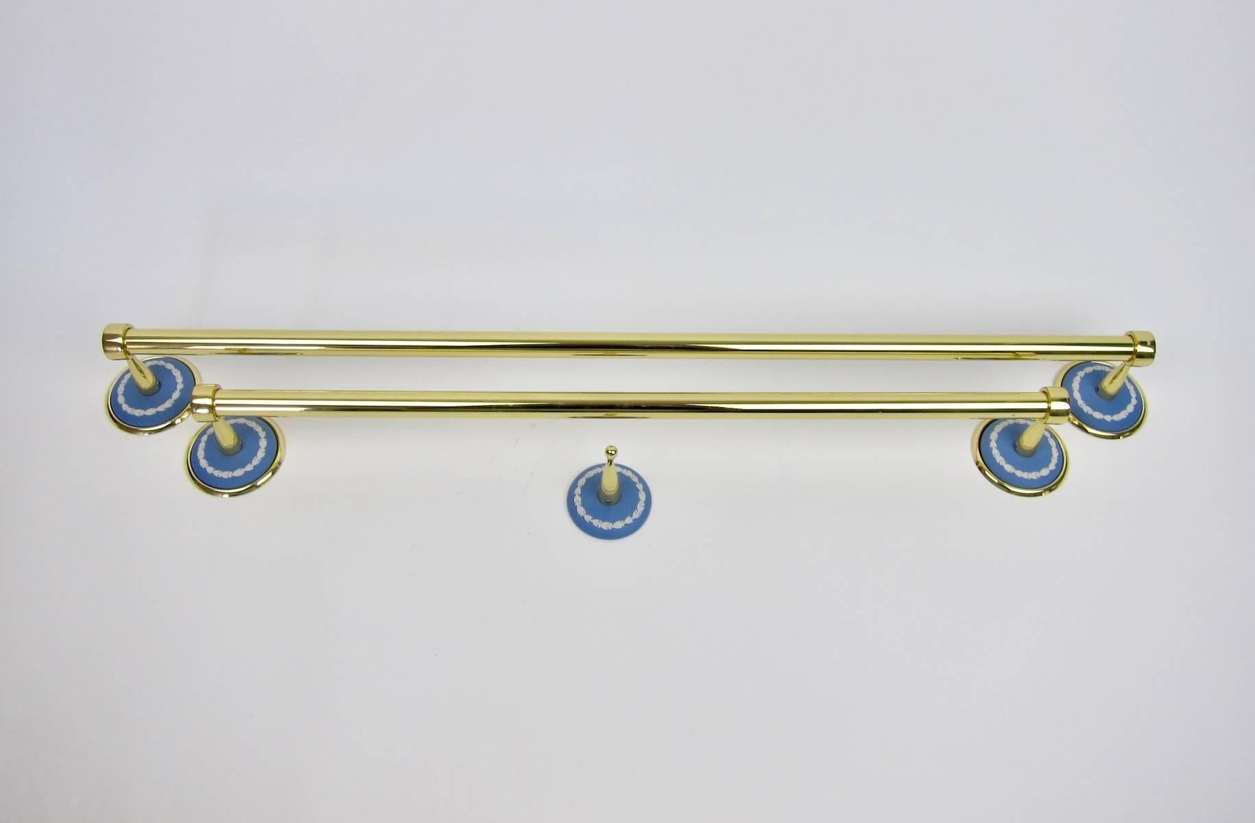 An unusual set of vintage accessories for the bath, consisting of two brass towel bars and a single hook with contrasting Wedgwood Jasper ware accents. The blue jasper discs are decorated with white blossom border garlands in low-relief.

Each