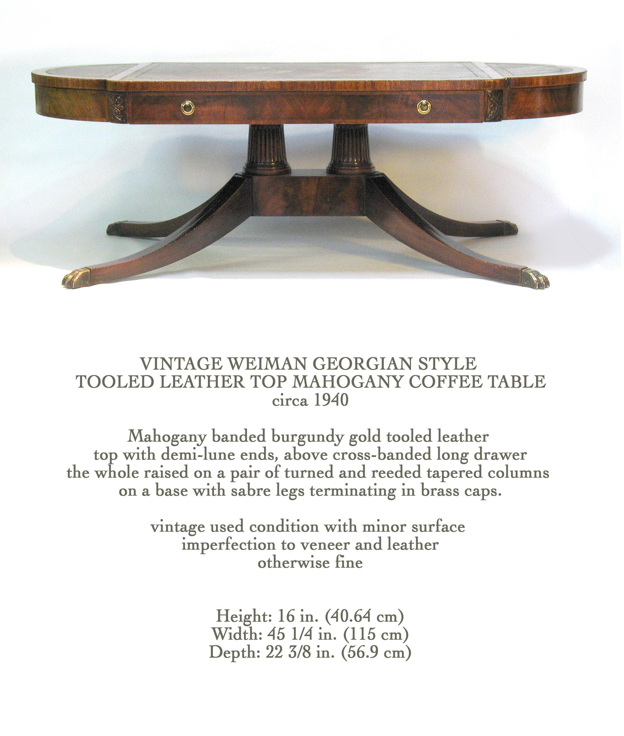 VINTAGE WEIMAN GEORGIAN STYLE 
TOOLED LEATHER TOP MAHOGANY COFFEE TABLE
circa 1940

Mahogany banded burgundy gold tooled leather 
top with demi-lune ends, above cross-banded long drawer
the whole raised on a pair of turned and reeded tapered