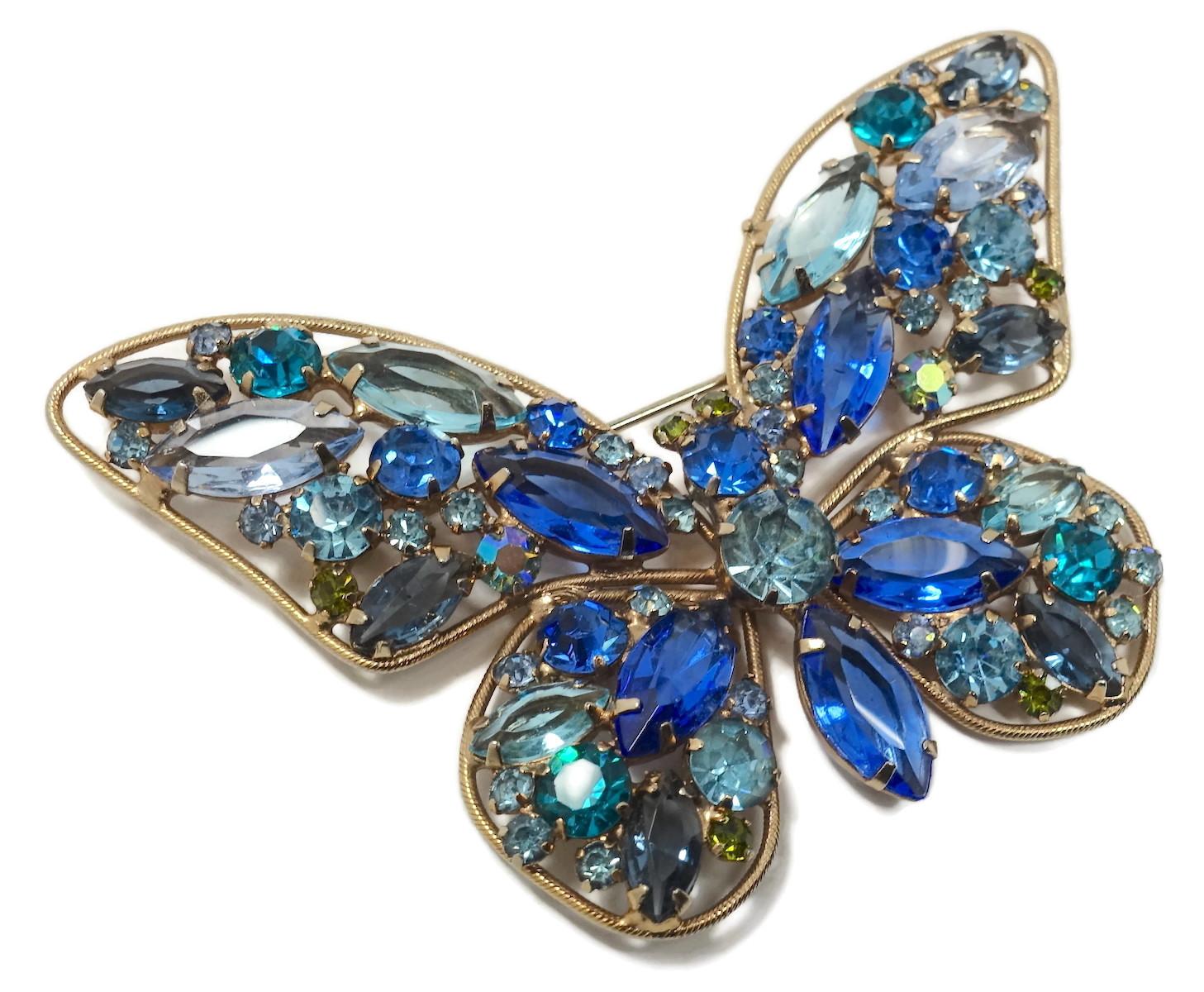 This vintage butterfly 1960s brooch reminds me of Weiss.  It features multi-color crystals in a gold tone setting.  In excellent condition, this brooch measures 3-1/4” x 2-1/8”.