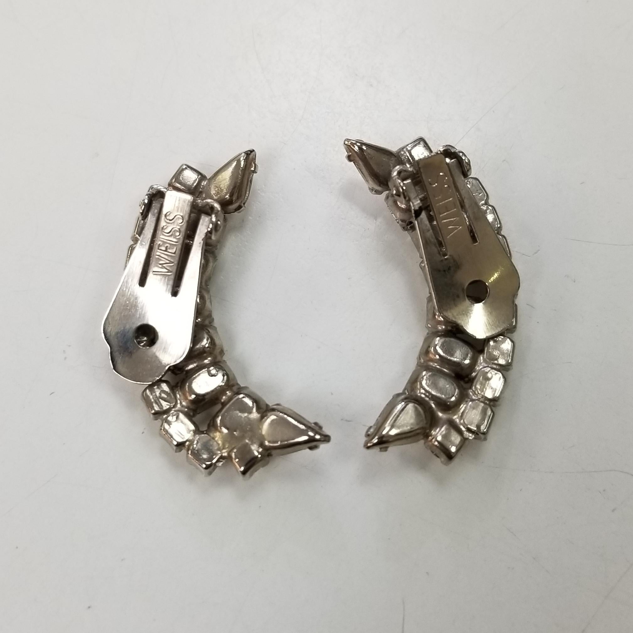 Vintage Weiss,1950s clear rhinestone earring.  The multi-cut rhinestones are configured in an abstract shape and are set in a silver-washed metal.