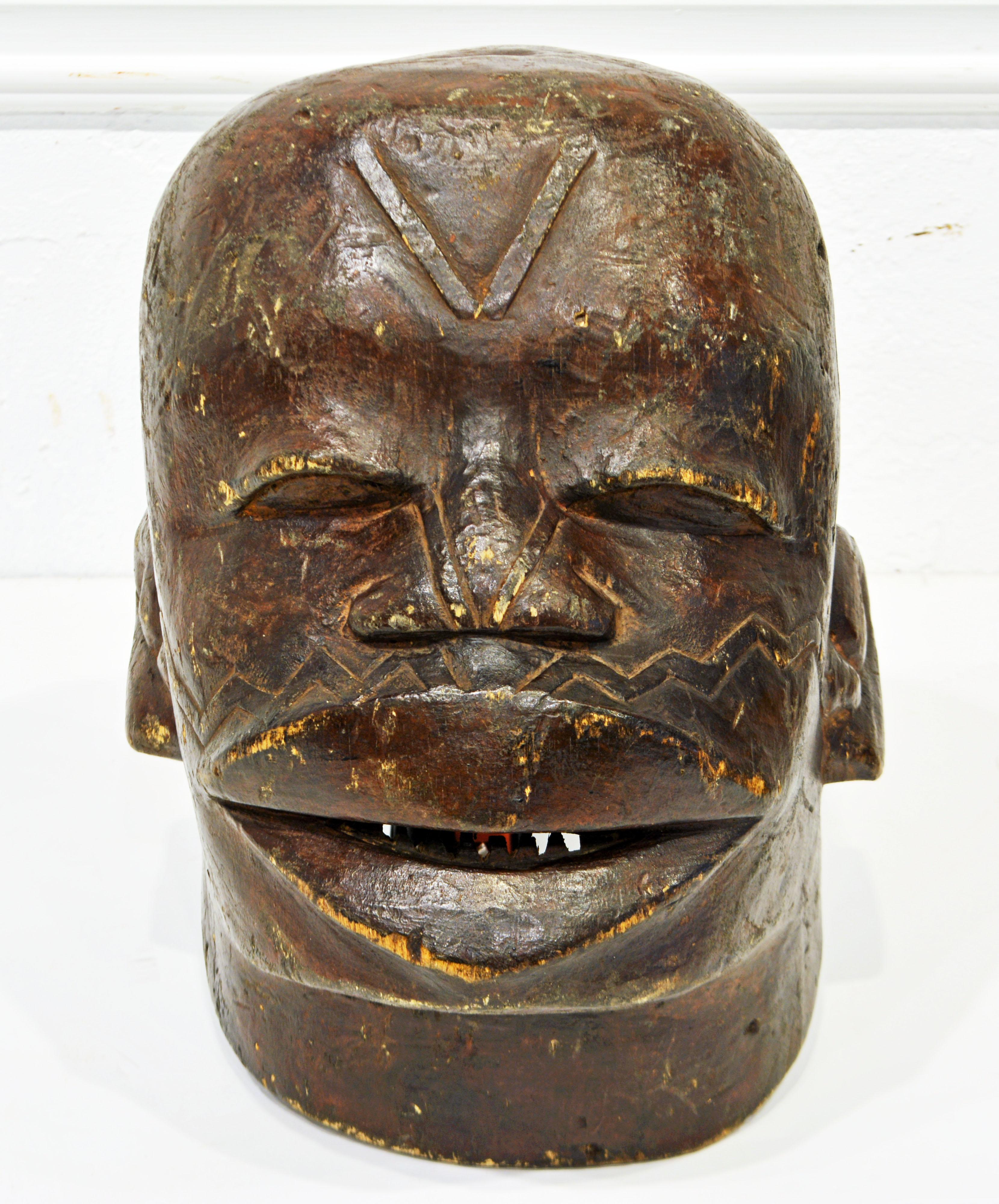This expressive Maconde Helmet mask from Mozambique or Tanzania (the Maconde people live in both countries) is carved in wood with good detail and traditional scarification marks in high relief. A dark surface treatment has been applied. These