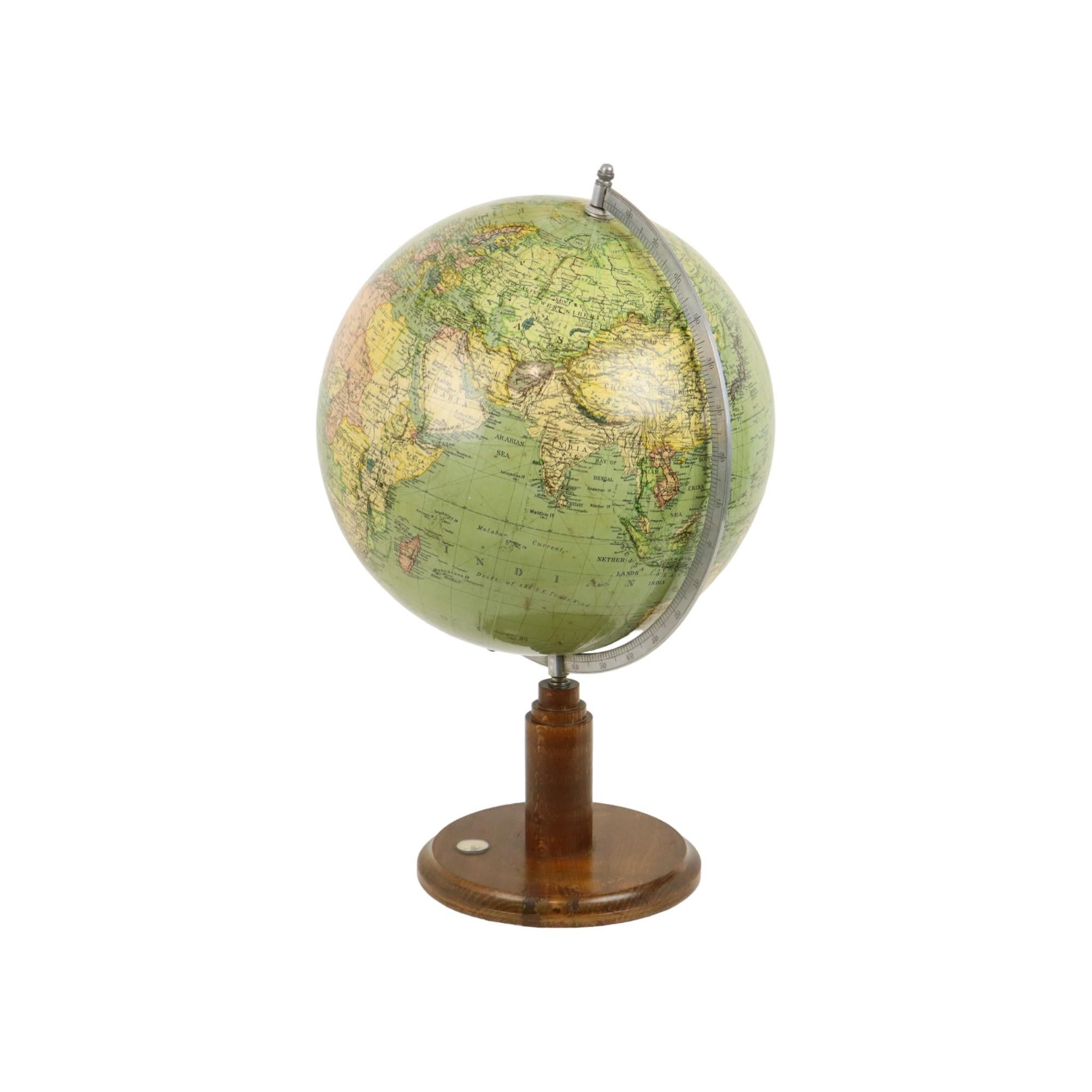 Bellissimo mappamondo inglese d'epoca con bussola, appoggiato su una base rotonda in quercia in stile art deco, datato anni '40-'50, stranamente privo di marchio di fabbrica.

La mappa mostra l'Africa Occidentale Francese, l'Indocina e il Congo