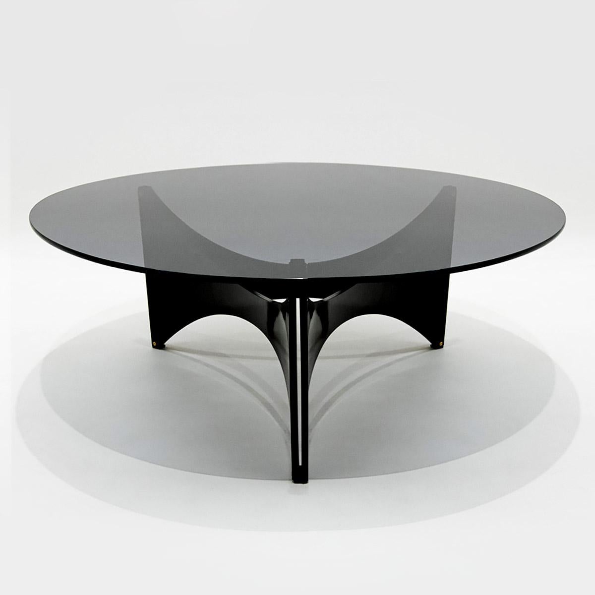 Vintage retro 1960s Werner Blaser tinted circular glass coffee table with black curved triangular plywood base for ‘t Spectrum.

Having worked with both Alvar Aalto and Mies van der Rohe the architect, designer and publicist Werner Blaser
