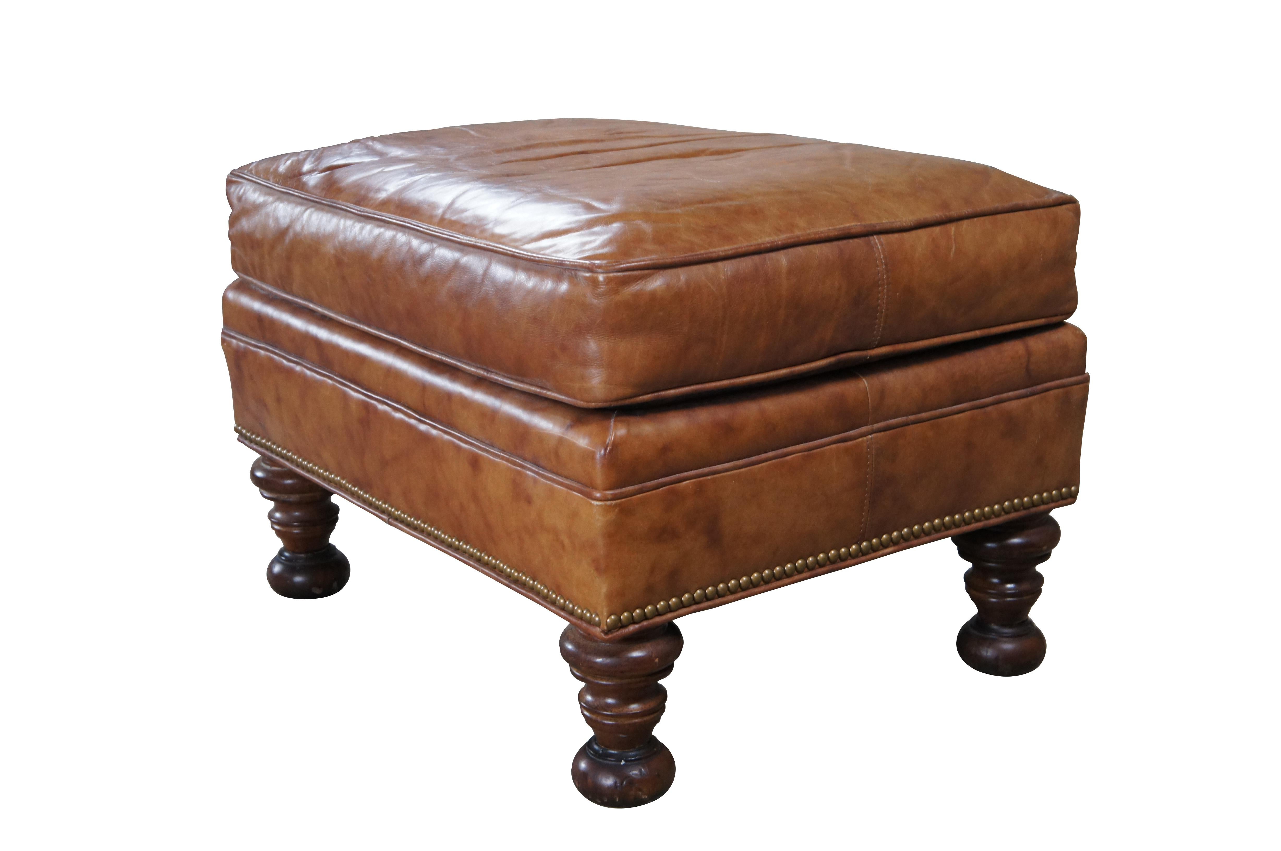 Late 20th Century leather upholstered ottoman or footstool by Wesley Hall. Features a rectangular frame with burnt orange leather, brass nailhead trim and turned mahogany feet. 

Wesley Hall is a family-owned furniture manufacturer that has been in