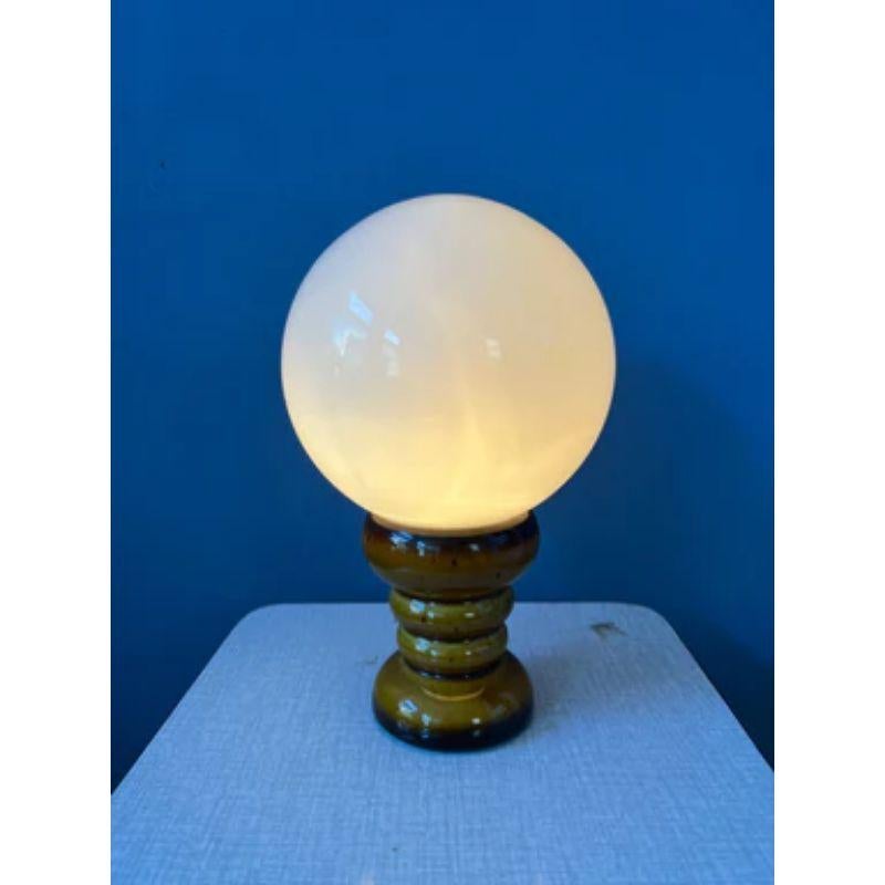 A small ceramic west germany table lamp with glass shade. The lamp requires one E14 lightbulb and currently has an EU-plug.

Dimensions: 
ø Shades: 12 cm
Height: 19 cm

Condition: Very good. The ceramic part has some visible lines running