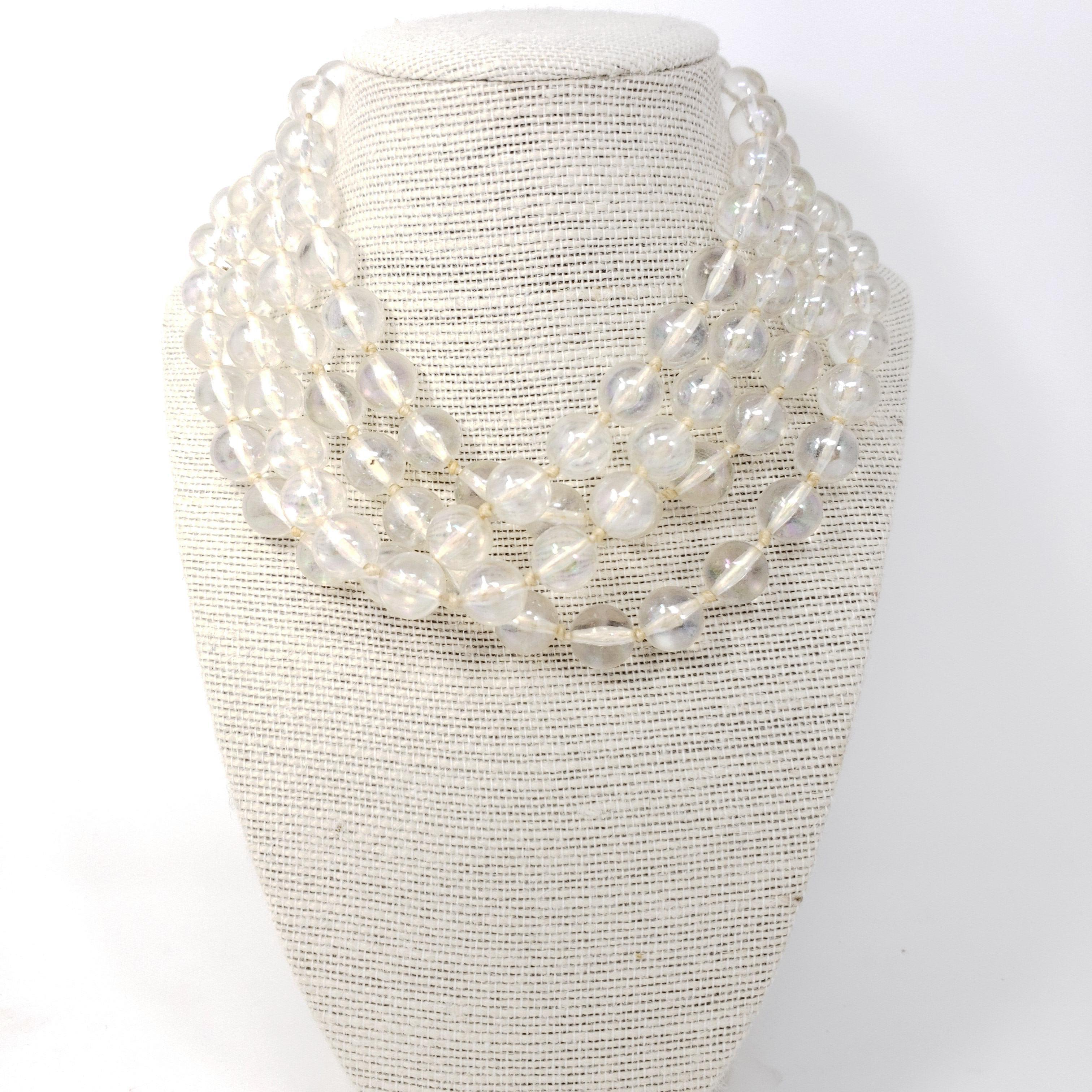 A stylish retro necklace originating in West Germany. Features clear iridescent beads on a knotted string necklace, secured with a gold-tone clasp. Very long - 62 inches around!

Marks / hallmarks / etc: W Germany