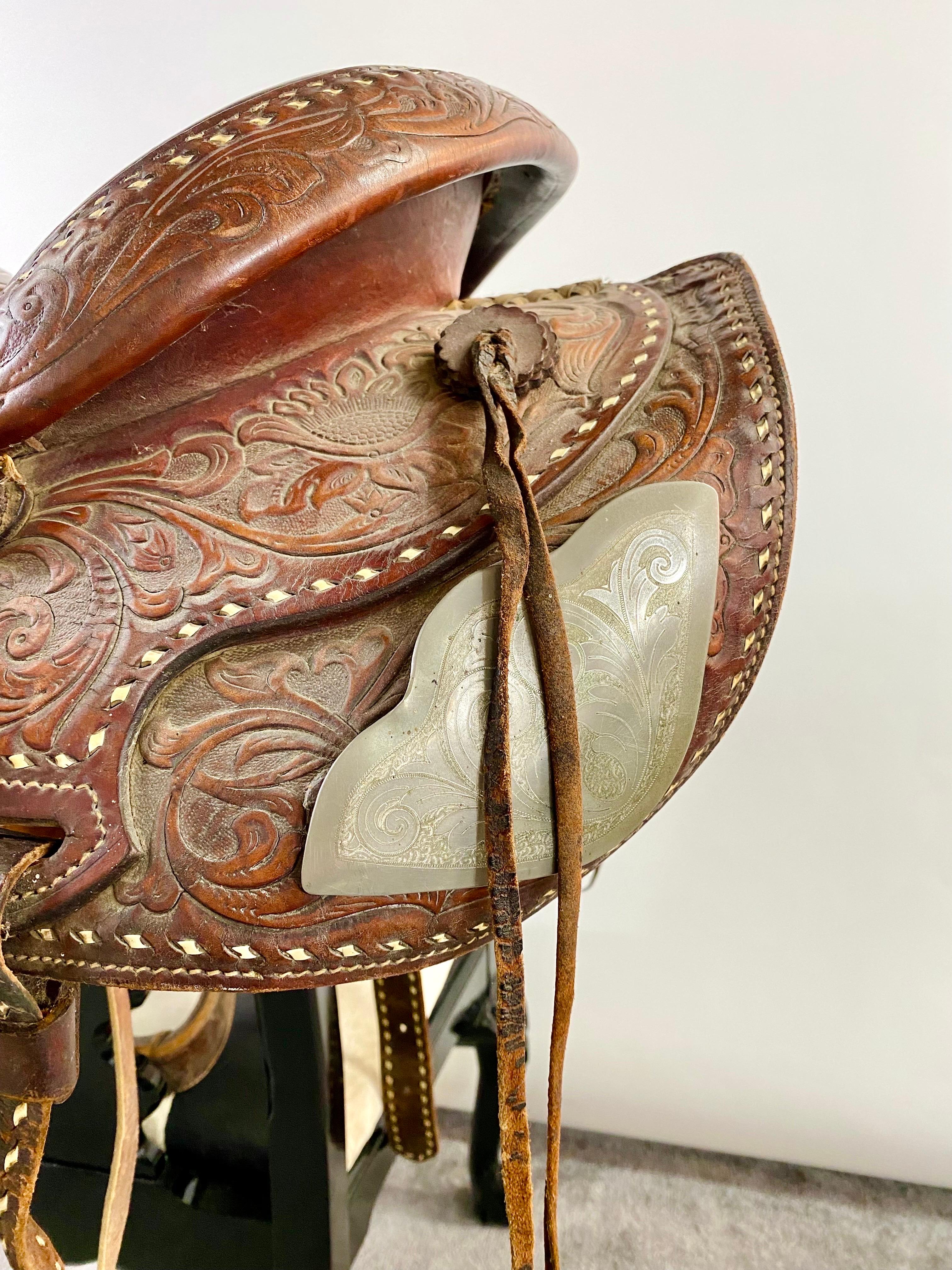 A high quality vintage western cowboy saddle. The saddle is handmade using genuine quality leather and shows impressive carving and design and is padded with wool from the inside. The saddle is numbered on the side.  This vintage leather cowboy