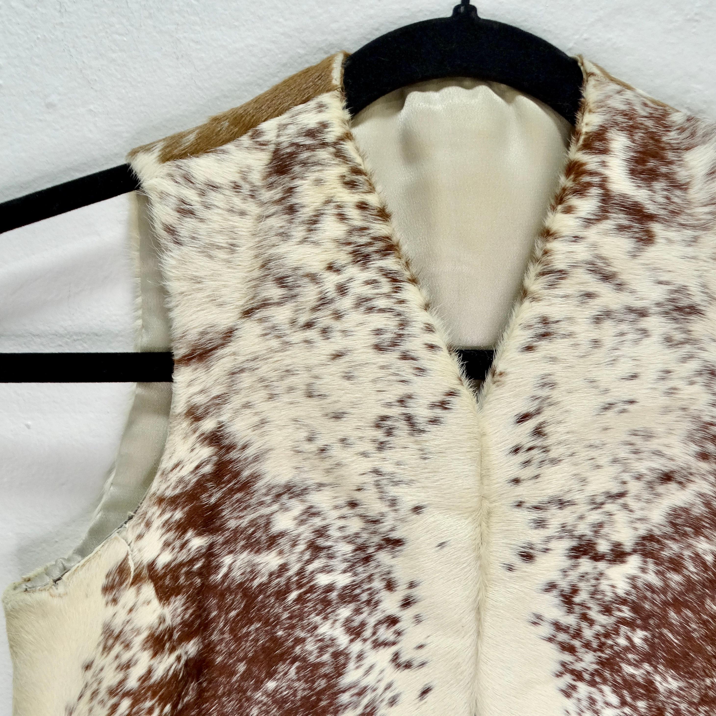 Elevate your Western-inspired look with this Vintage Western Cowhide Vest. Crafted in the 1980s, this vest features a striking combination of white and brown cowhide fur that exudes rustic charm and timeless appeal.

Lined with silk for added