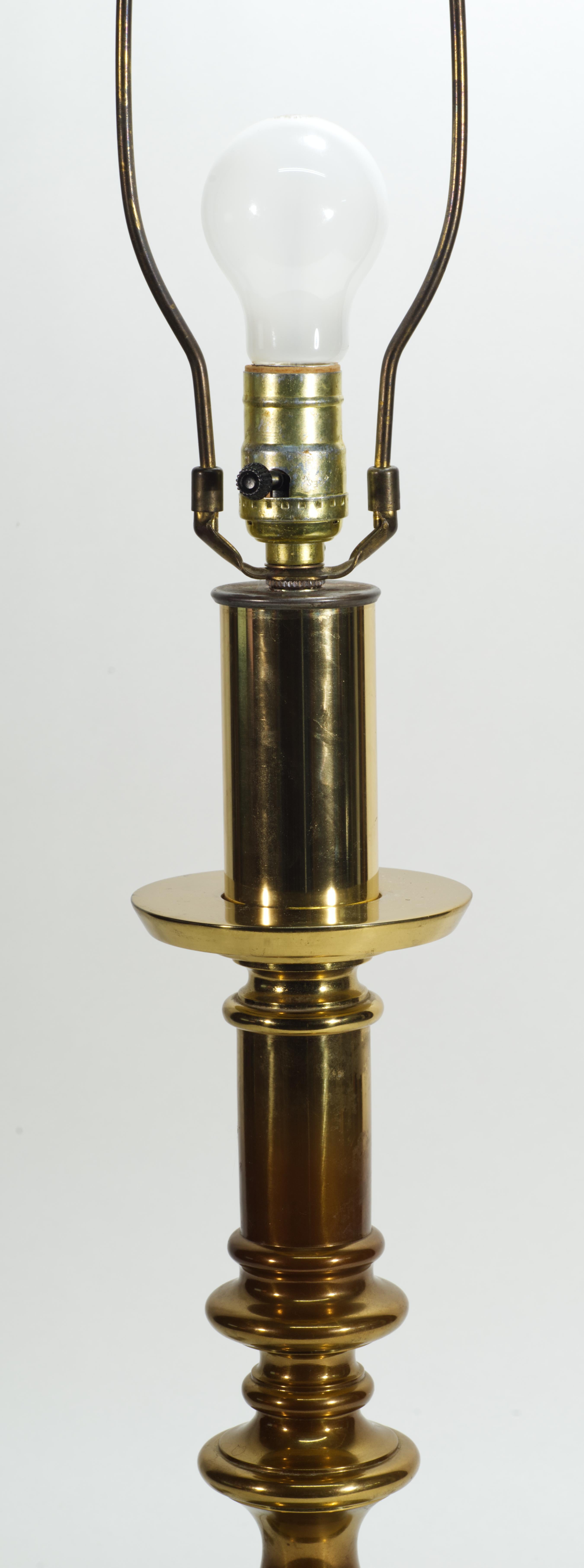 Vintage large bronze or brass table lamp features sculptural baluster or candlestick shaped form with the stepped circular base. Tall, statuesque lamp with reflective metal texture is fitted with the original harp and bronze finial.

The lamp
