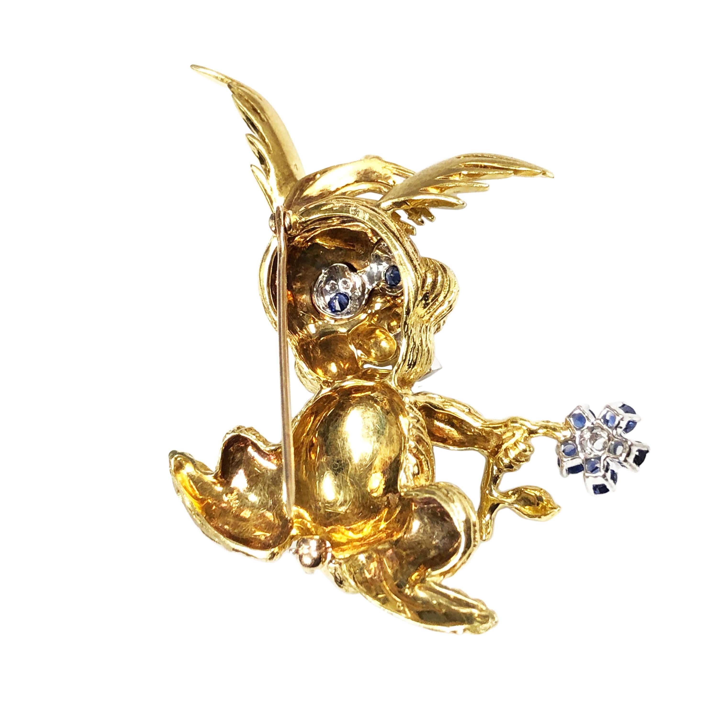 Circa 1970 18k yellow Gold Whimsical Bunny Rabbit Brooch, measuring 2 inches in length X 2 inches wide and weighing 29.7 Grams. Extremely well made, very nicely detailed and Having Sapphire and Diamond Eyes, a Ruby Nose, Diamond Tooth and holding a