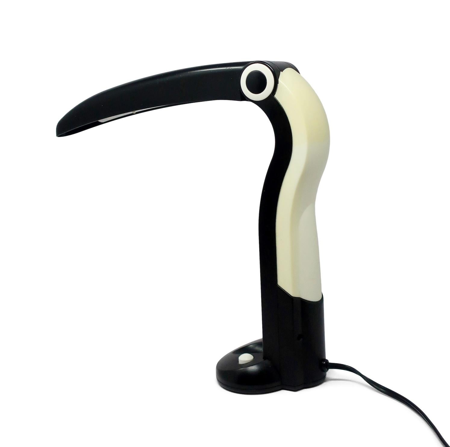 An excellent postmodern white and black folding desk lamp in the form of toucan.  Endlessly charming, it takes a single fluorescent bulb and has on/off switch on the base.

In good vintage condition with wear consistent with age and use, including
