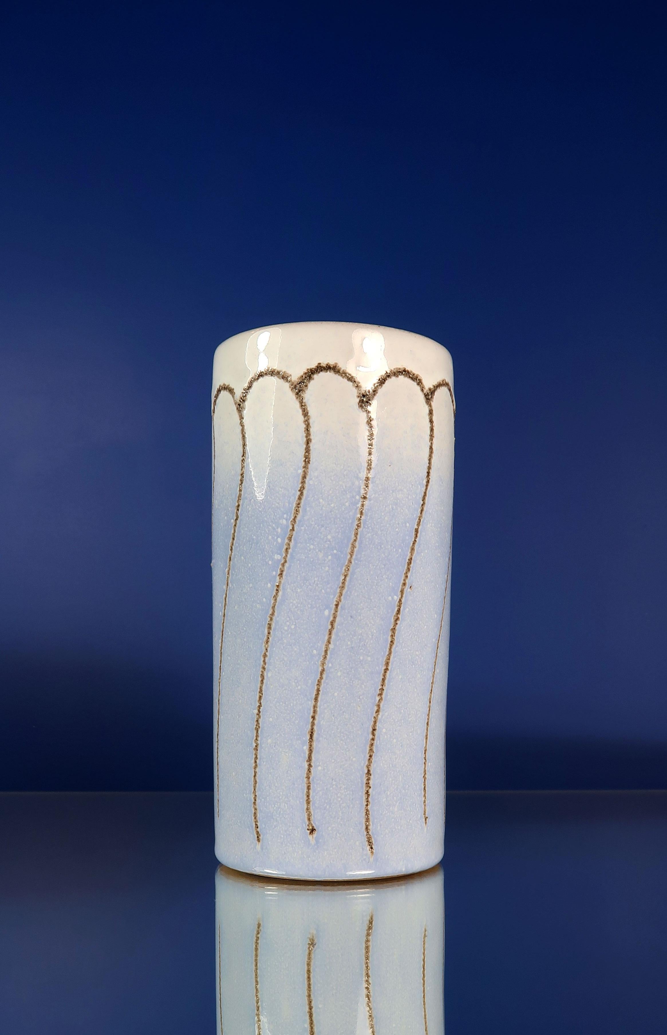Cylinder shaped Mid-Century Modern handmade ceramic vase by East German manufacturer Strehla. Greyish brown vertical relief lines with an organic swirl. White glazed top gradually turning light blue down the vase. Brown glaze on the inside. Stamped