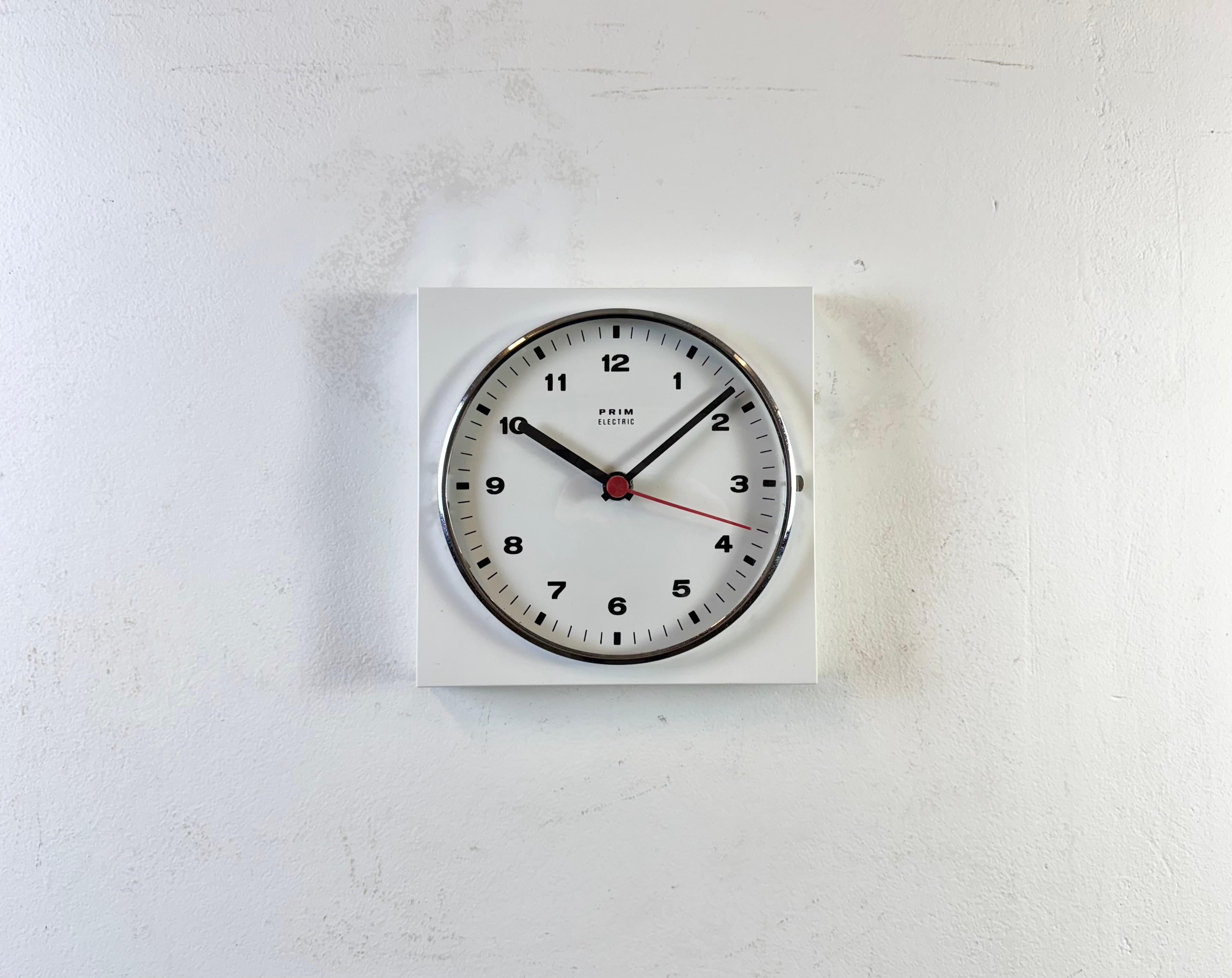Horloge murale carrée vintage a été fabriquée par Prim dans l'ancienne Tchécoslovaquie au cours des années 1970.... Whiting présente un corps en bakélite blanche  et un couvercle en verre transparent convexe avec anneau chromé. Le mécanisme