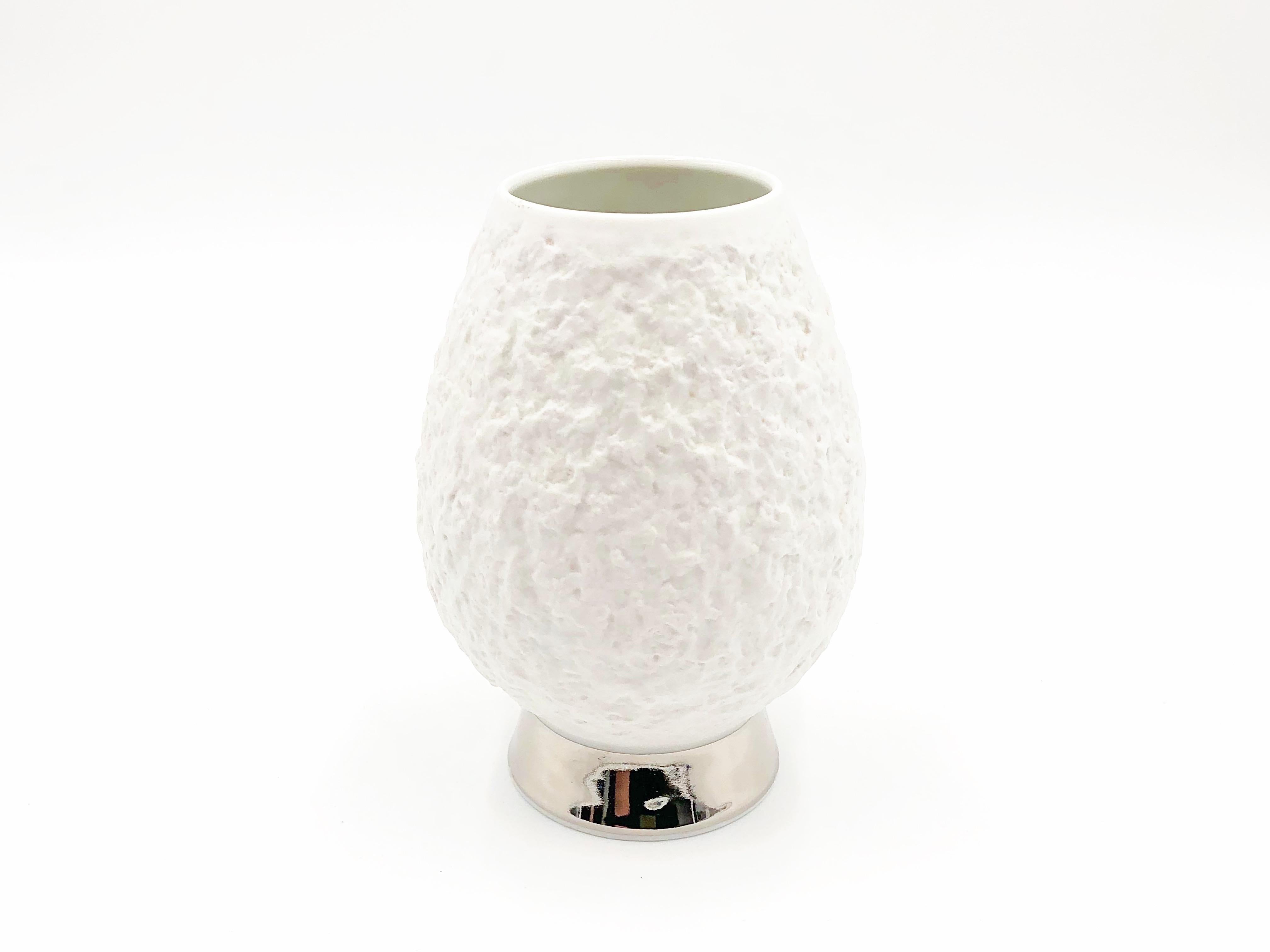 Mid-Century Modern porcelain vase by KPM Royal Porcelain Factory in Germany, circa 1960s.

White matte bisque unglazed textured porcelain vase with silver plate detail on base. Interior is glazed. Marked KPM on base.

Details:
- 6.2