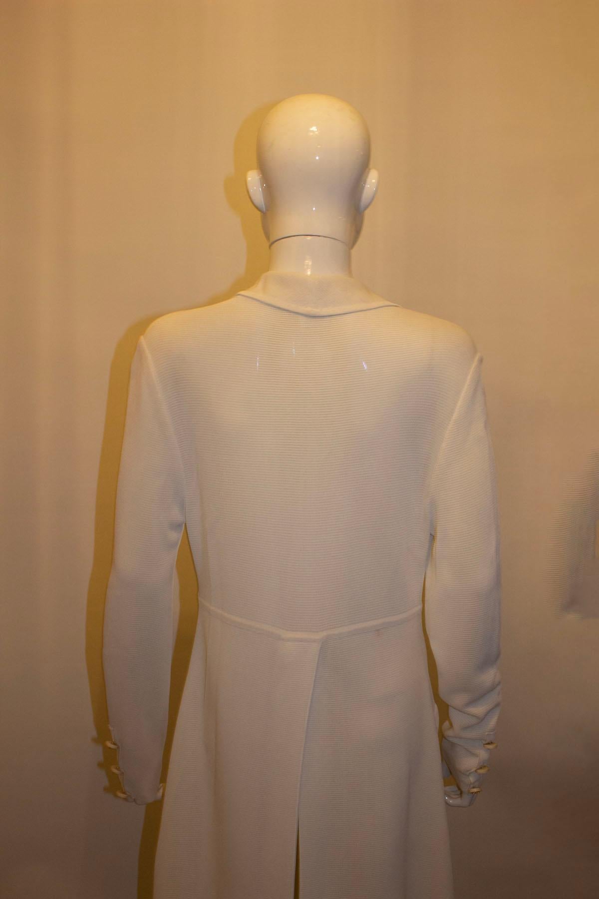 A super vintage white coat dress by Celine. The coat is made of a heavy viscose ( hangs beautifully)  and has all the original buttons. It has a cut away collar,  2 flap pockets  on the front, and a 22'' slit on the back. The coat is unlined..